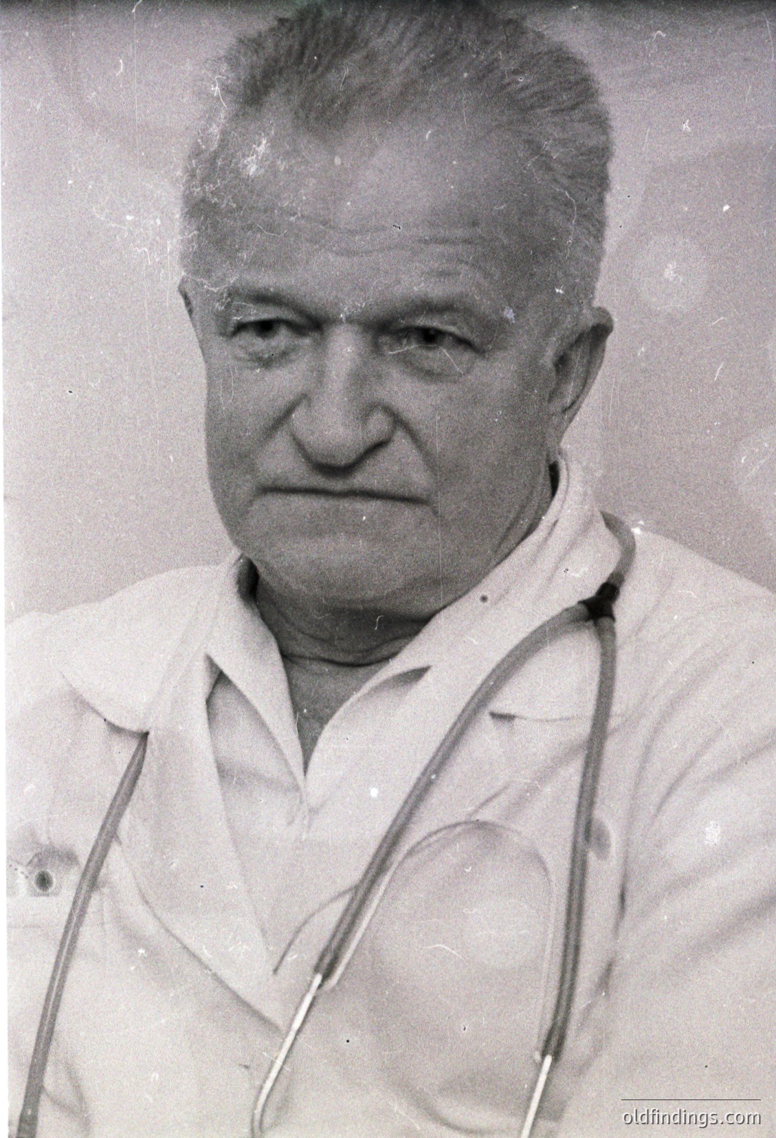 Portrait of an older man in a white lab coat with stethoscope draped around neck, likely a physician. Mid-20th century medical photography style, suggesting clinical or professional documentation.