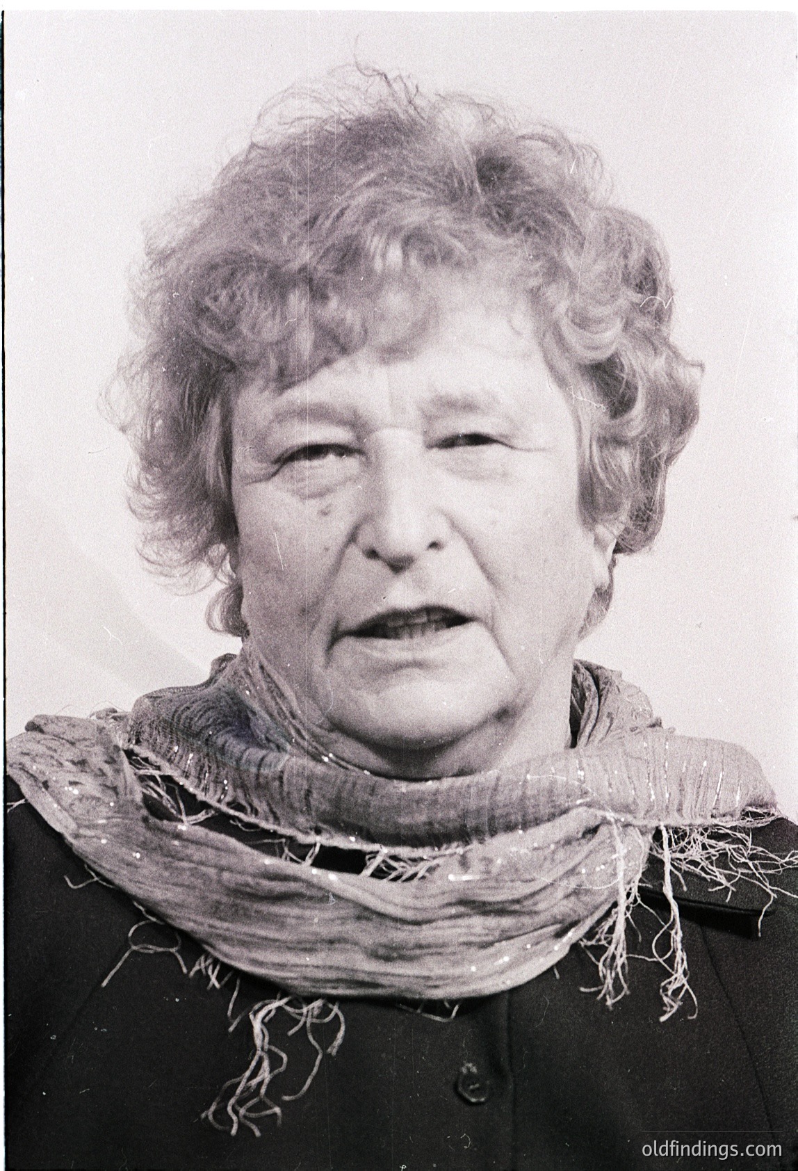 Portrait of an elderly woman in mid-profile, wearing a textured scarf and dark blazer. Style suggests mid-20th century (1950s–1970s). Expression conveys seriousness or contemplation.