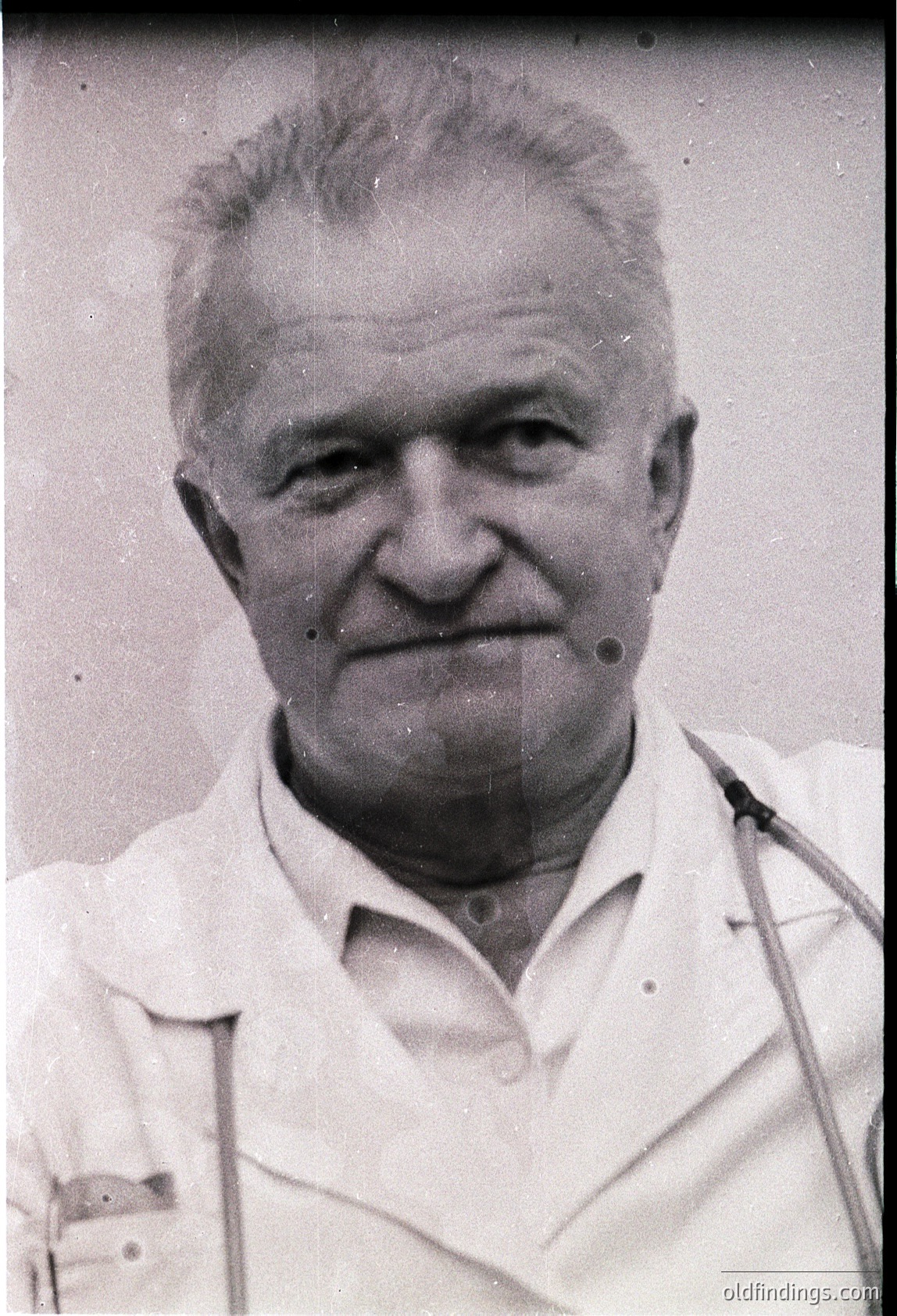 Portrait of an elderly man in a white lab coat, likely a doctor or scientist, mid-20th century. His stethoscope draped around his neck suggests medical profession. Classic vintage style with slight grain.