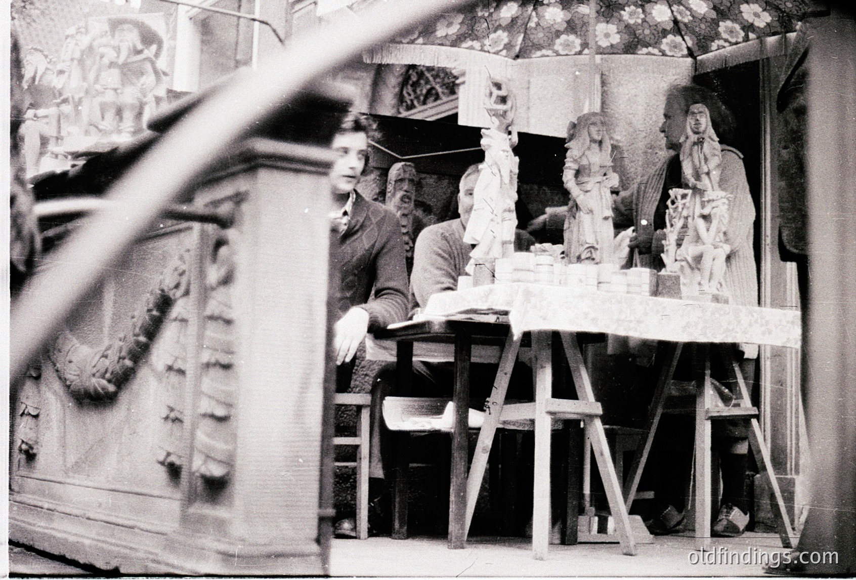 Artisans crafting intricate plaster sculptures in a workshop, likely 1950s–1970s. Visible tools, unfinished religious figures, and ornate architectural reliefs in background suggest traditional craftsmanship.