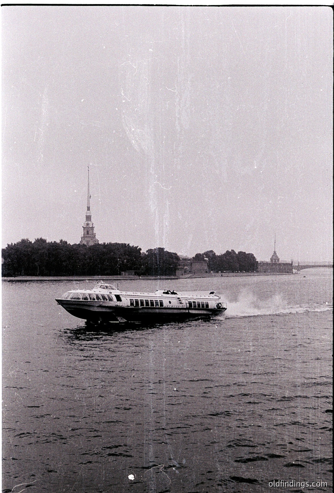 1960s hydrofoil ferry crossing Neva River, St. Petersburg, USSR. Iconic Peterhof Palace and Peter and Paul Fortress spires in background. Classic mid-century Soviet-era transport design.