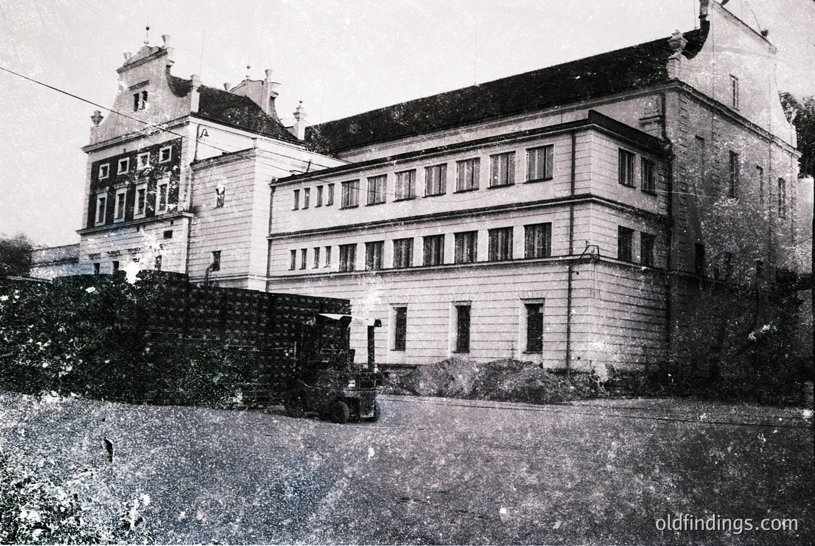 Three-story historic building with symmetrical façade, featuring tall rectangular windows and decorative gables. Likely early-to-mid 20th-century European architecture, possibly institutional or residential.