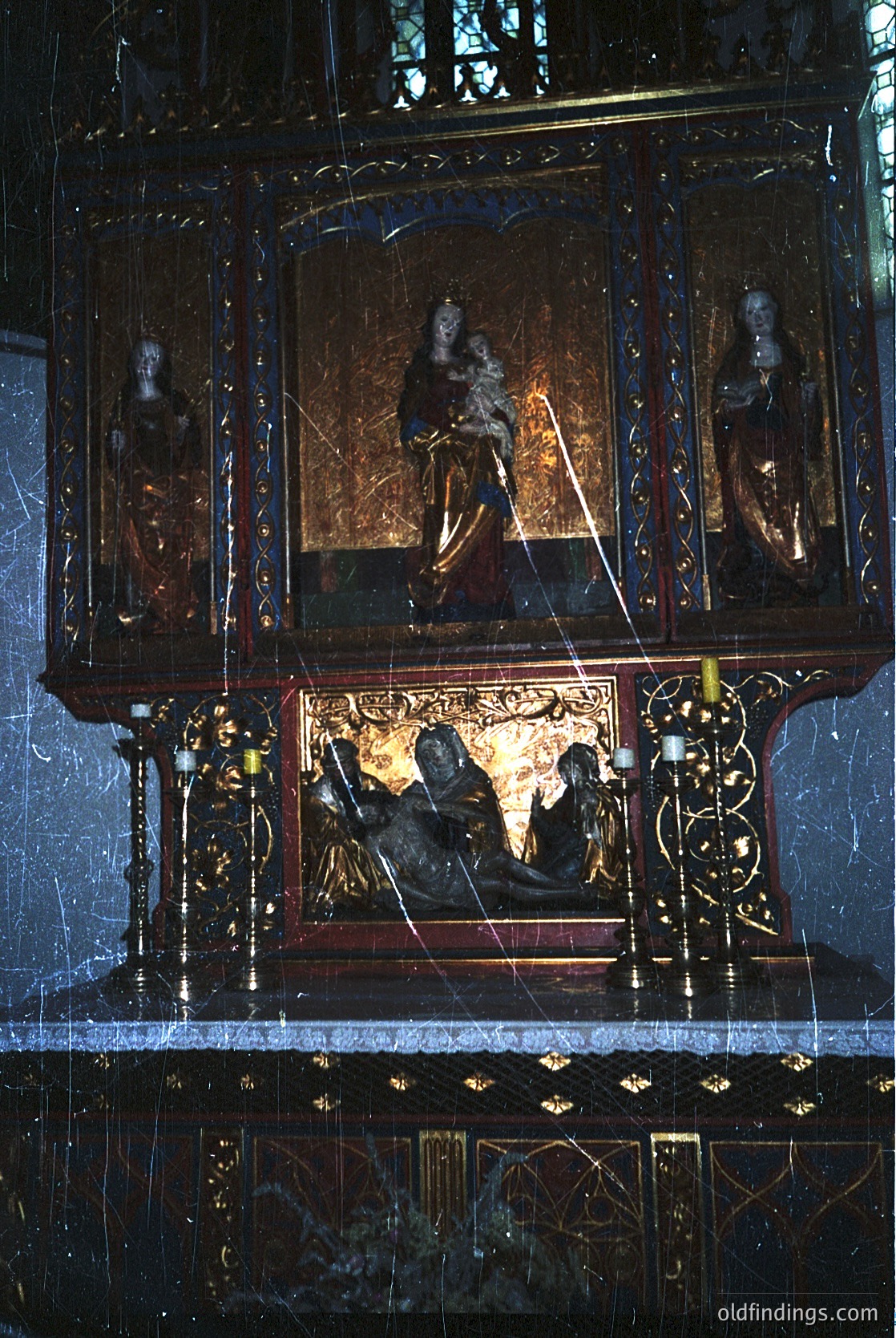 Baroque-style altar piece featuring gilded woodwork, intricate carvings, and religious iconography. Central panel depicts Christ enthroned with saints flanking; lower section shows the Pietà. Ornate clockwork elements and stained-glass windows enhance the ornate design. Likely European, 17th–18th century.