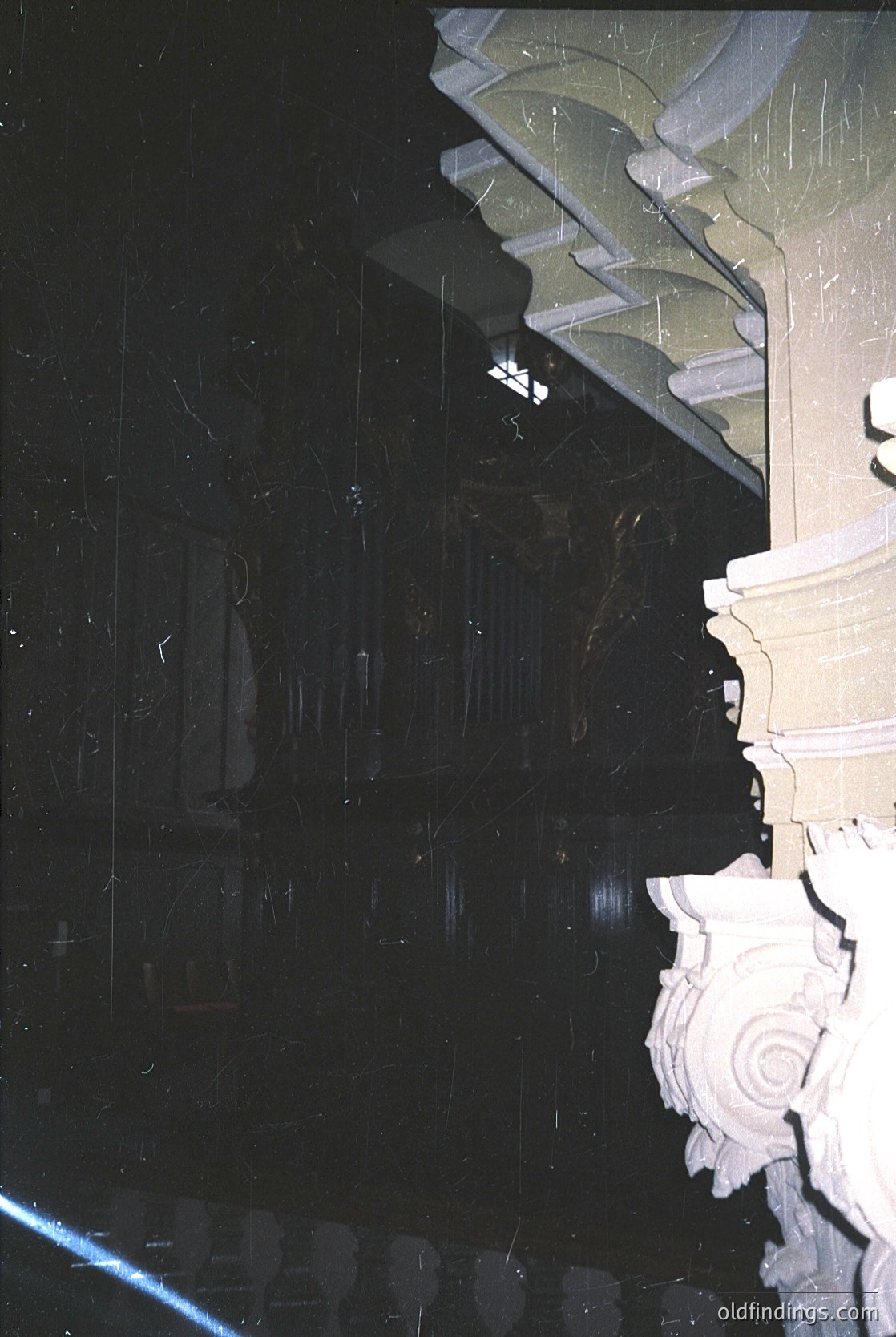Close-up of ornate **Art Nouveau-style** stone balustrade with intricate scrollwork and floral motifs, likely part of a grand staircase or balcony. Dark, moody lighting enhances texture and depth. Potential European architectural heritage, mid-20th century.