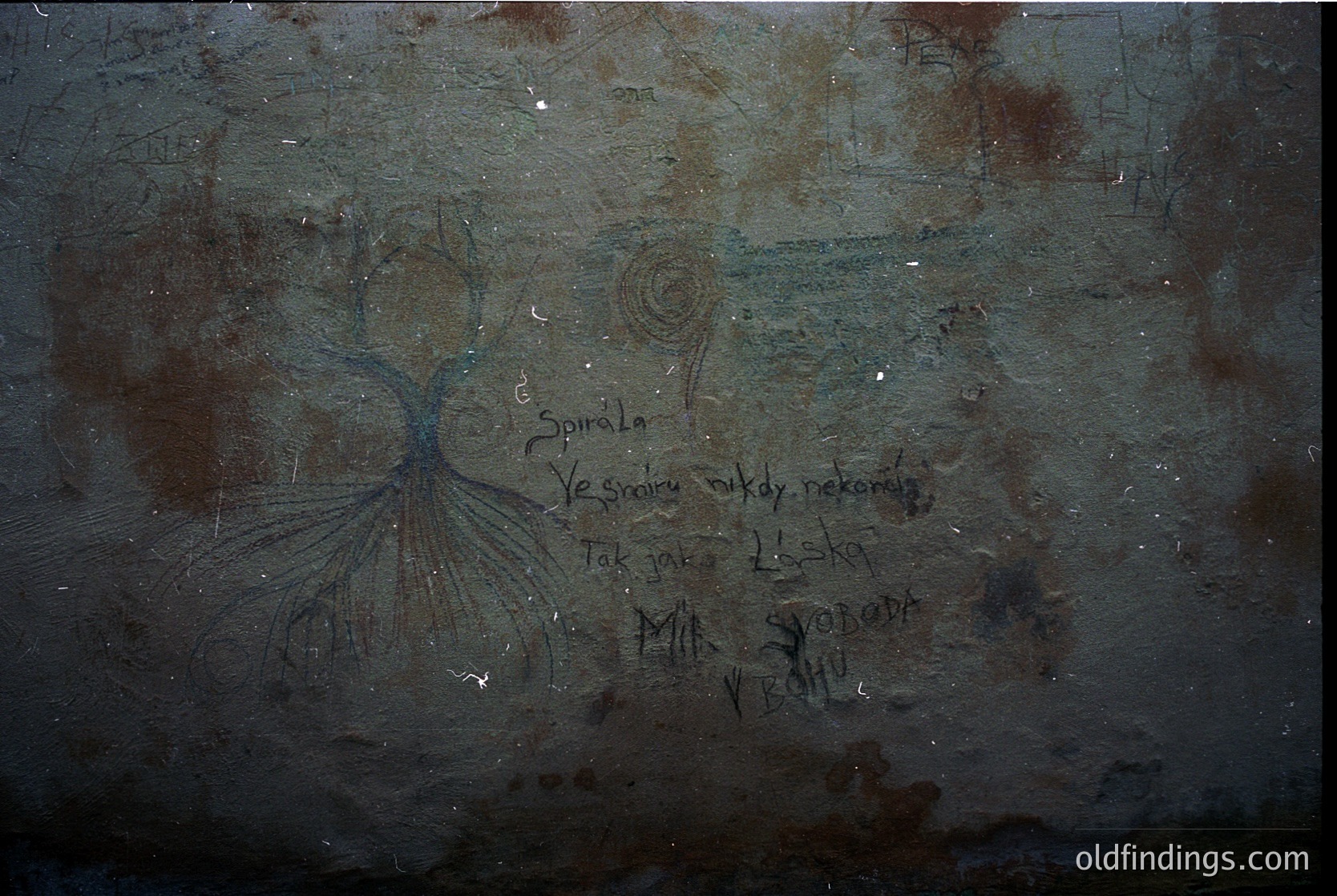 Vintage graffiti on aged concrete wall featuring Cyrillic text: *"Спирала, Вечность, как некомик, так как жизнь – свобода в бою."* Abstract spiral design above. Likely Eastern European, 20th-century urban art.