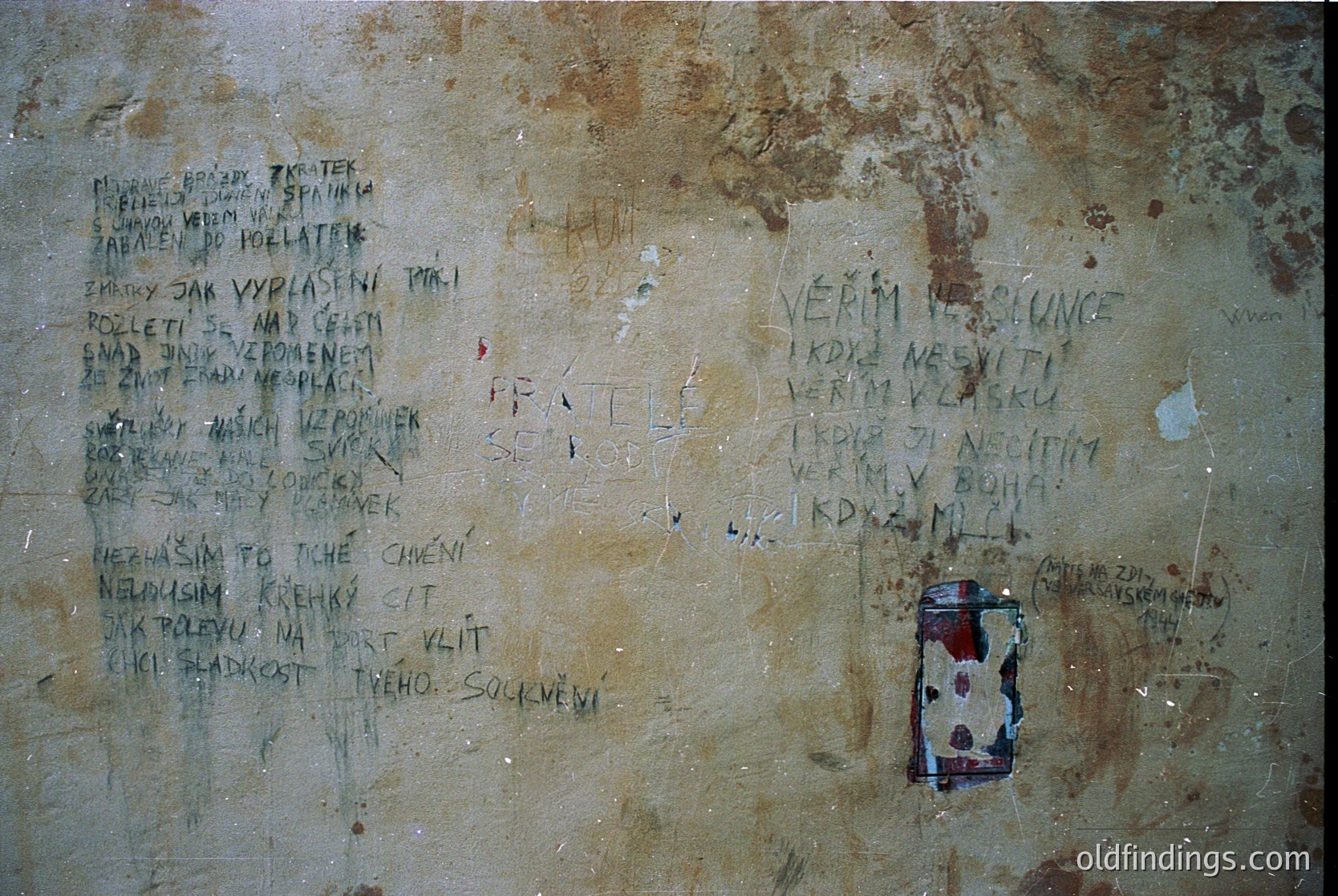 Graffiti-covered concrete wall with Cyrillic inscriptions and a faded sticker. Text appears to be poetic or philosophical, likely Bulgarian. Surface shows signs of aging and weathering, suggesting an outdoor or semi-exposed environment. Potential historical or cultural documentation value.
