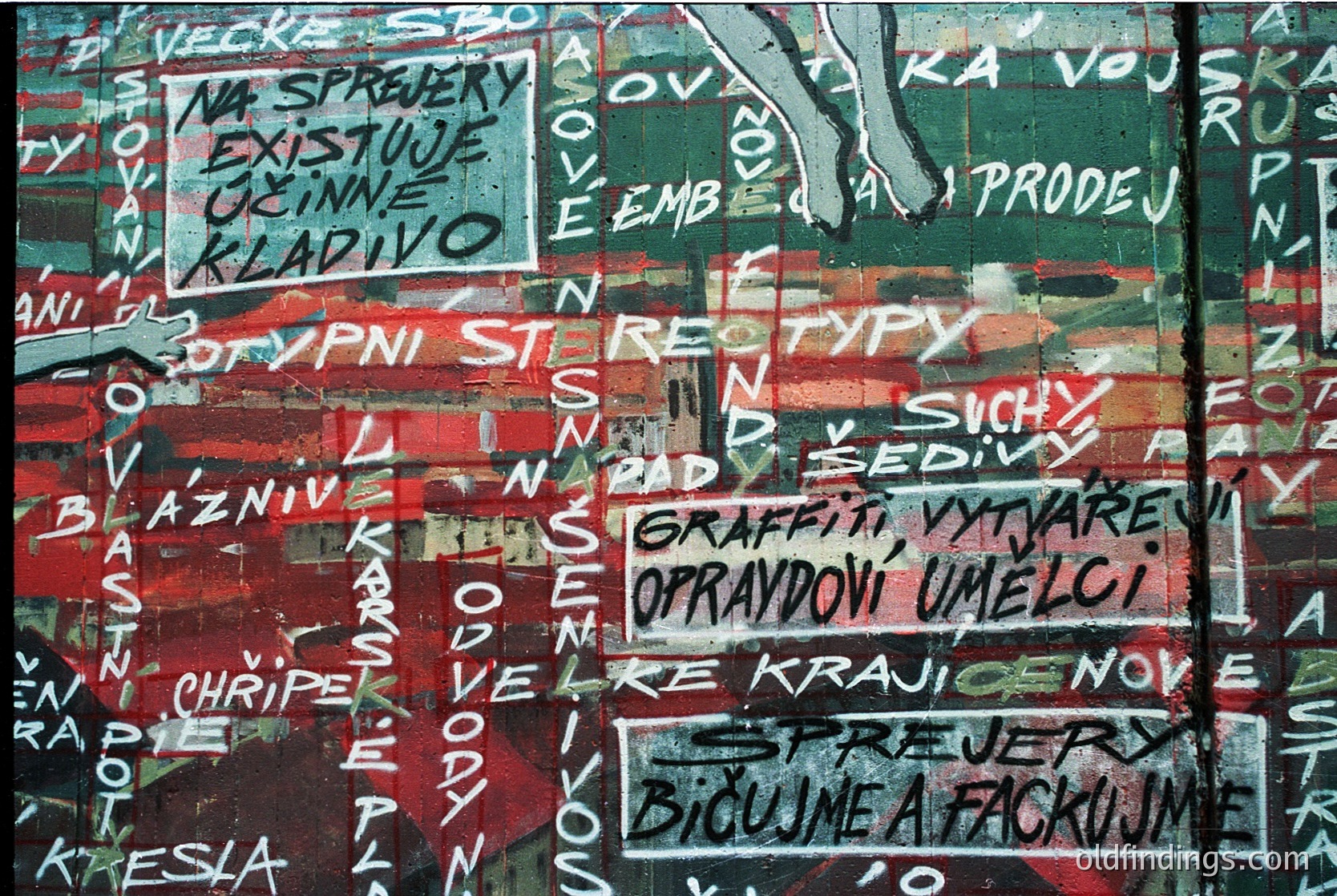 Vibrant graffiti wall featuring bold, layered text in Czech/Slovak with red, white, and black paint. Prominent phrases include *"Existuje kladivo"* and *"Graffiti vytváří opravdové umění."* Urban street art style, likely from **1980s–1990s** Central Europe.