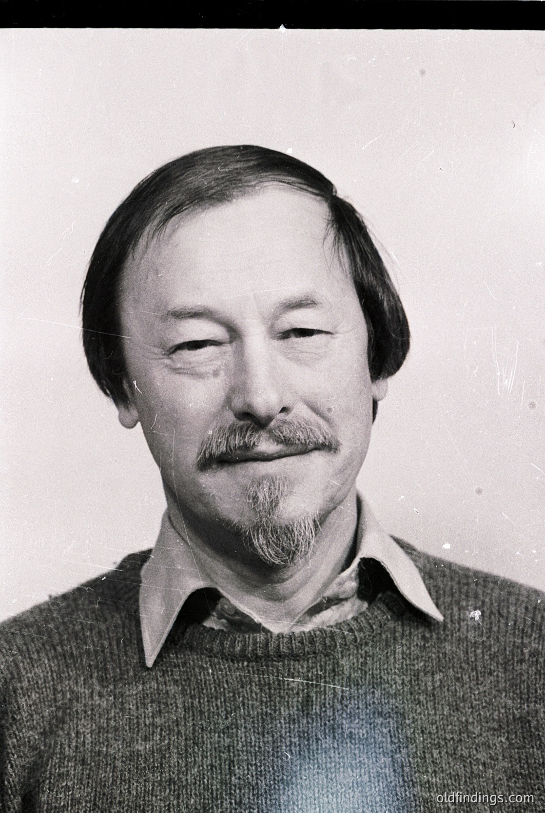 Portrait of a man with a mustache and beard, wearing a collared sweater. Classic 1970s-1980s headshot style, likely for professional or identification purposes.