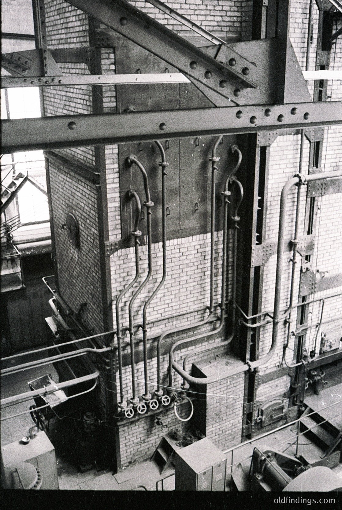 Industrial-era distillery interior featuring copper stills, brass valves, and intricate piping network. Brick walls and metal beams highlight 19th–early 20th century craftsmanship.