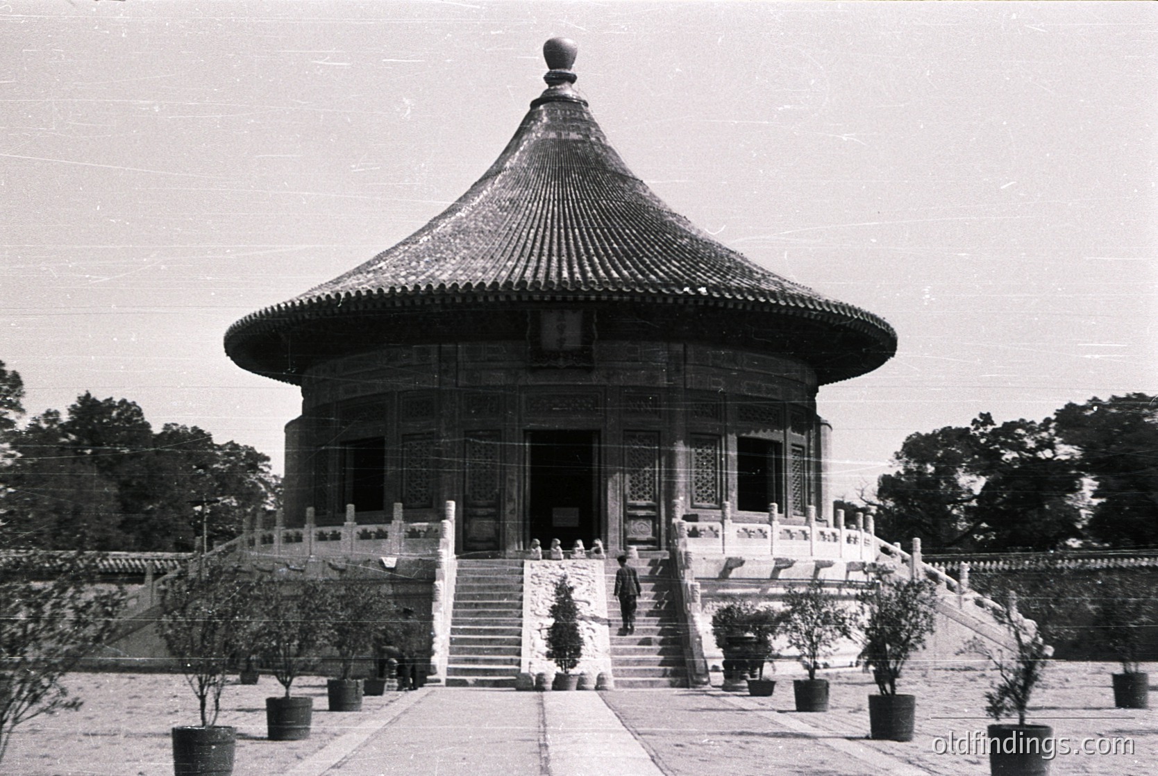 Classic Ming/Qing dynasty pavilion with curved, tiled roof and ornate eaves, set in a landscaped garden. Stone steps lead to an elevated entrance framed by carved railings. Potted plants flank the pathway, suggesting a serene, formal setting. Likely --- *Note: While the exact location isn’t identifiable, the style aligns with Imperial Beijing gardens (e.g., Summer Palace). The architectural cues suggest late Qing (1800s) or early Republican era.*