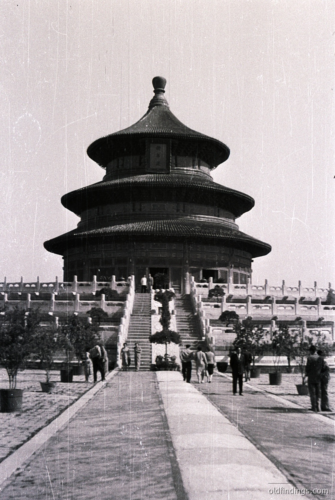 Classic **Temple of Heaven** circular hall in Beijing, China, showcasing Ming Dynasty architecture. Symmetrical stone pathway leads to the triple-tiered, octagonal roof with upturned eaves. Mid-20th century black-and-white photograph captures visitors in traditional attire.