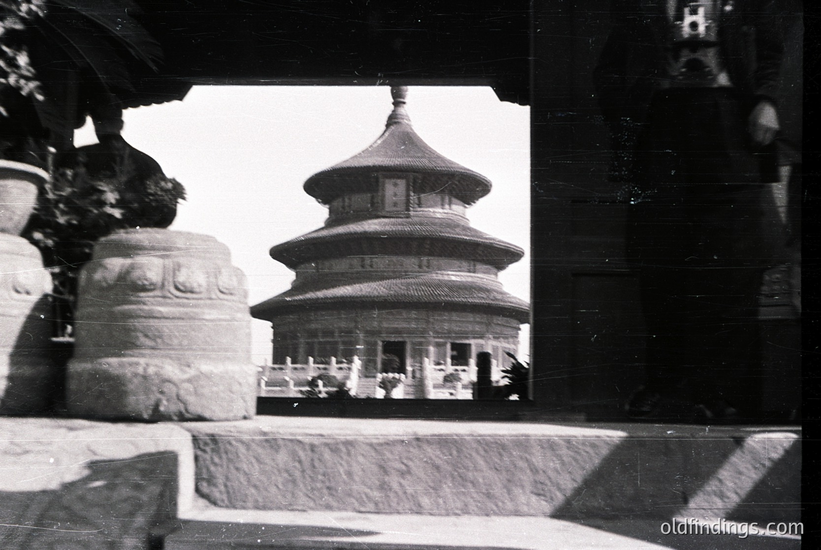 Classic three-tiered pagoda framed by stone window ledge, likely . Mid-20th century black-and-white shot captures traditional Chinese architecture’s layered eaves and curved roof. Stone carvings and shadow play add depth. Ideal for historical research on or architectural studies.