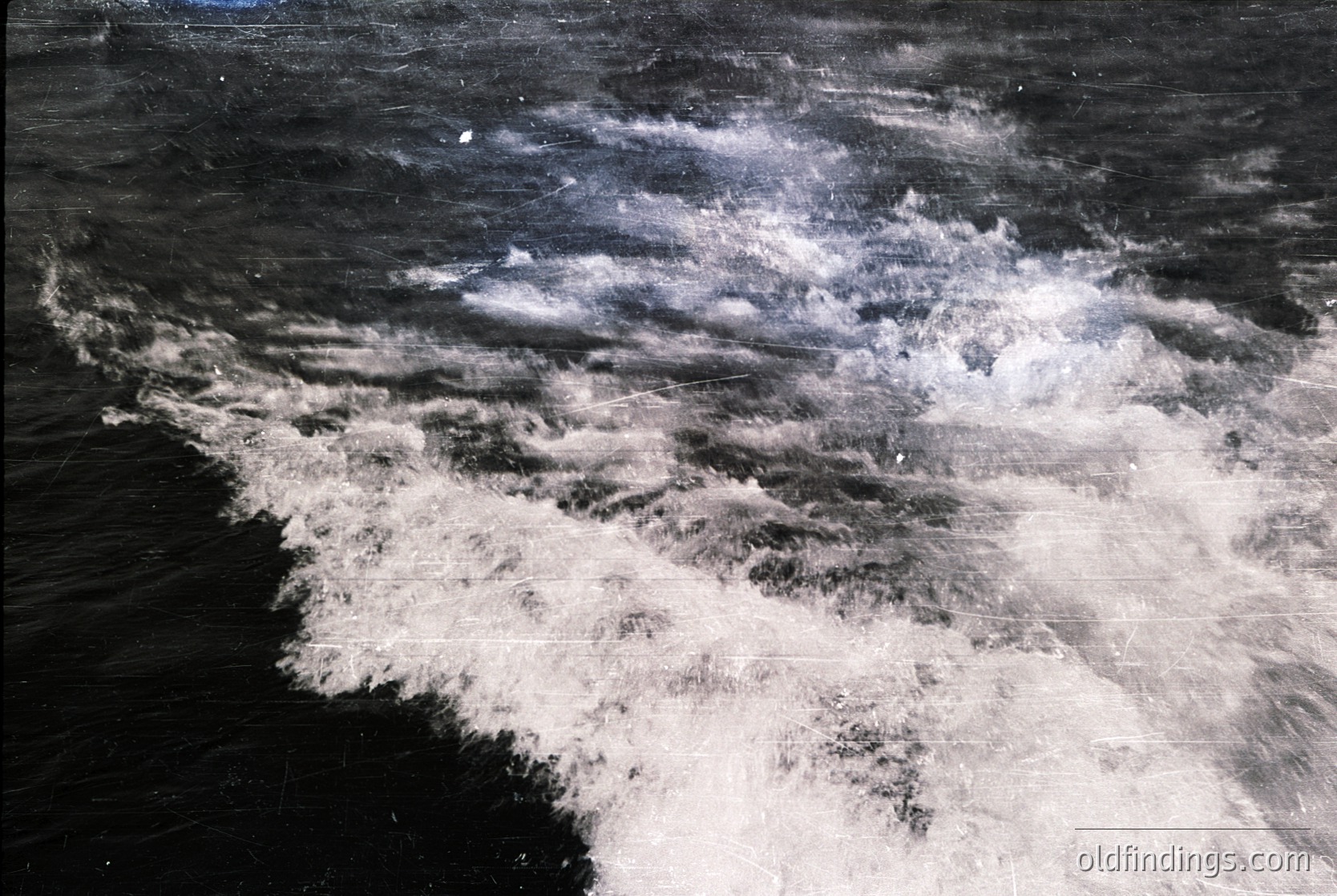 High-contrast monochrome shot of turbulent ocean waves crashing against a rocky shore. Dramatic texture captures frothy white foam and dark water. Ideal for moody coastal or weather-inspired visuals.