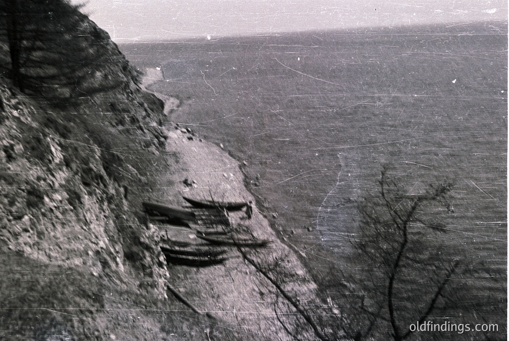 Vintage black-and-white aerial view of a **stepped cliffside terrace** with agricultural plots, likely for viticulture or dry farming. The layered rock formations and narrow pathways suggest ancient or traditional farming techniques. The expansive, flat landscape hints at a Mediterranean or semi-arid region.