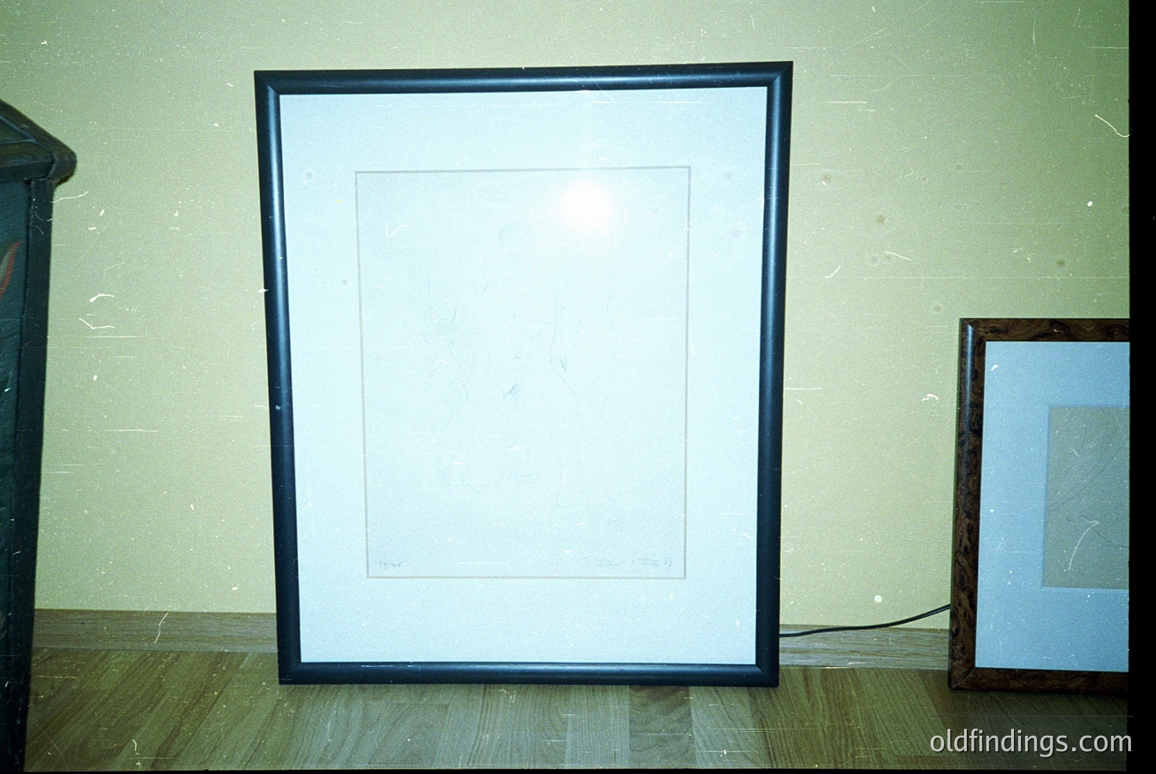 Empty black-framed canvas on textured wall, minimalist interior. Empty frame suggests potential for art display or design study. Likely mid-20th century residential setting.