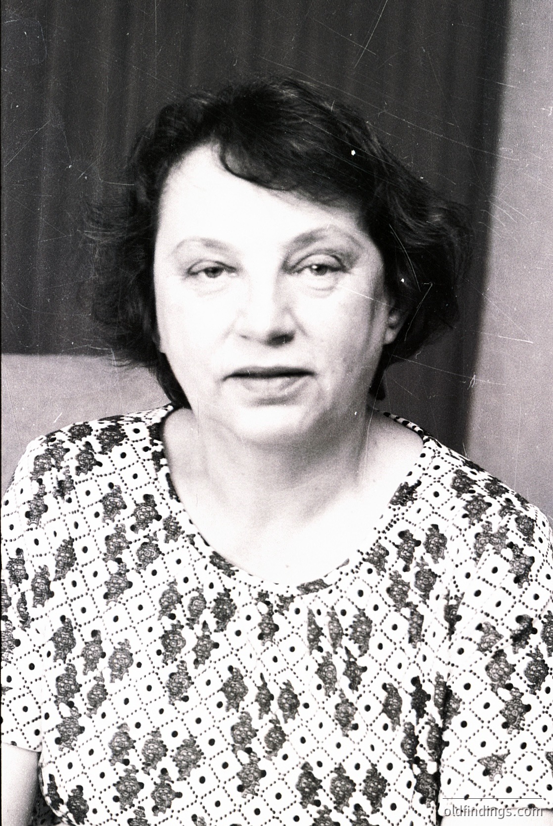 Portrait of an individual in a floral-patterned blouse with black polka dots, taken in mid-20th century. Soft focus and vintage monochrome style suggest or portraiture.