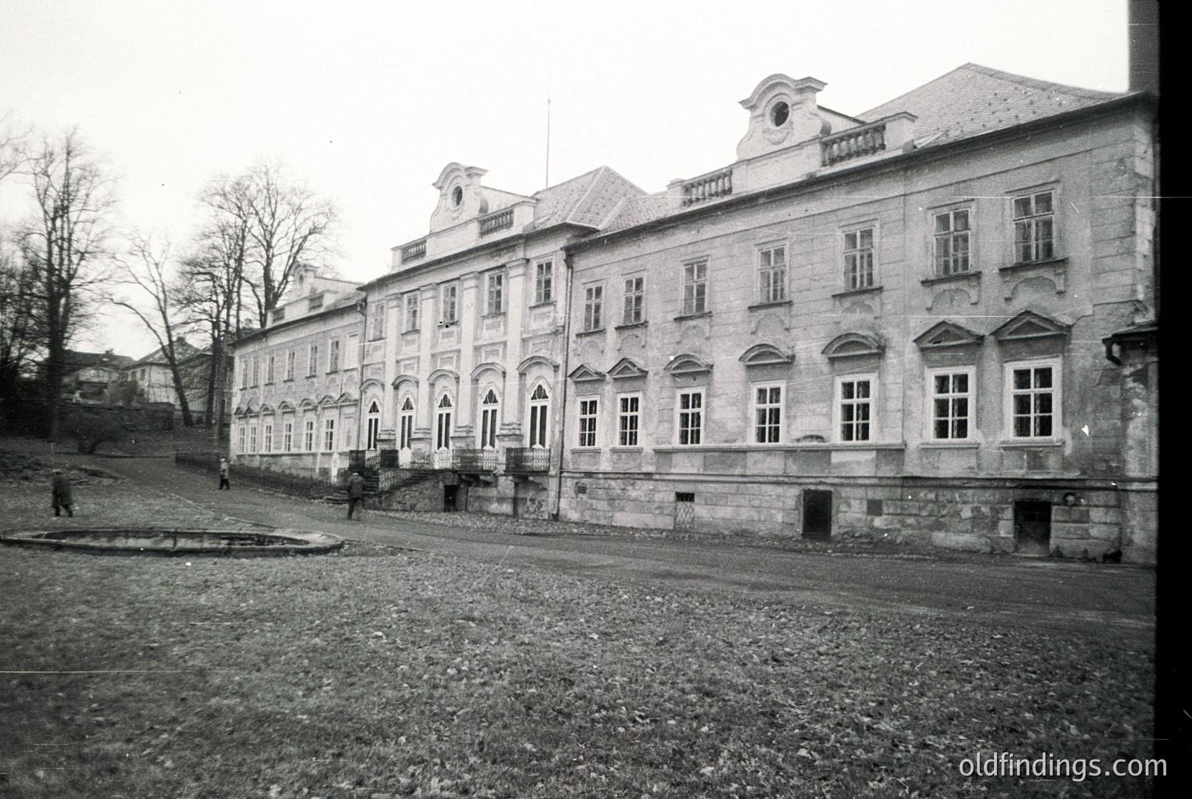 Neoclassical stone building with symmetrical façade, arched windows, and decorative cornices. Likely institutional or public use. Mid-20th century European architecture.