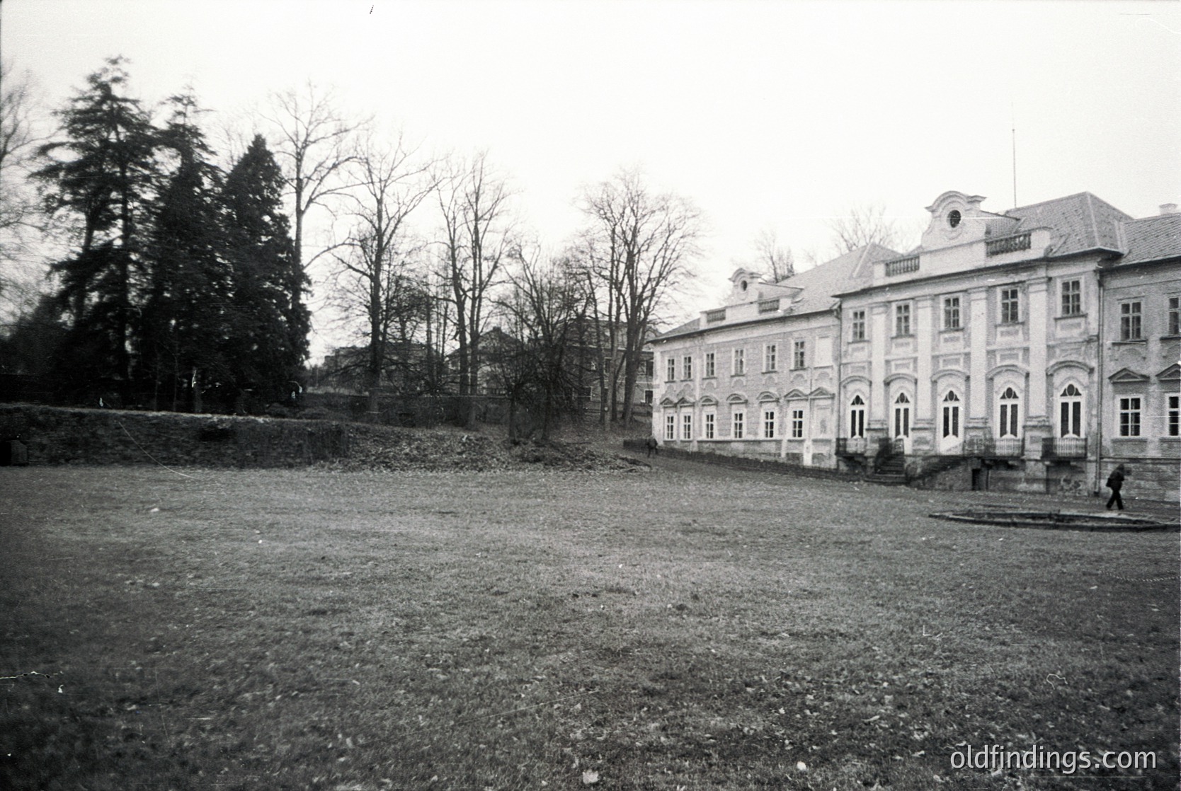 Neoclassical mansion with symmetrical façade, arched windows, and mansard roof in a barren landscape. Architectural details include decorative cornices and a central entrance. Likely early-to-mid 20th century European estate.