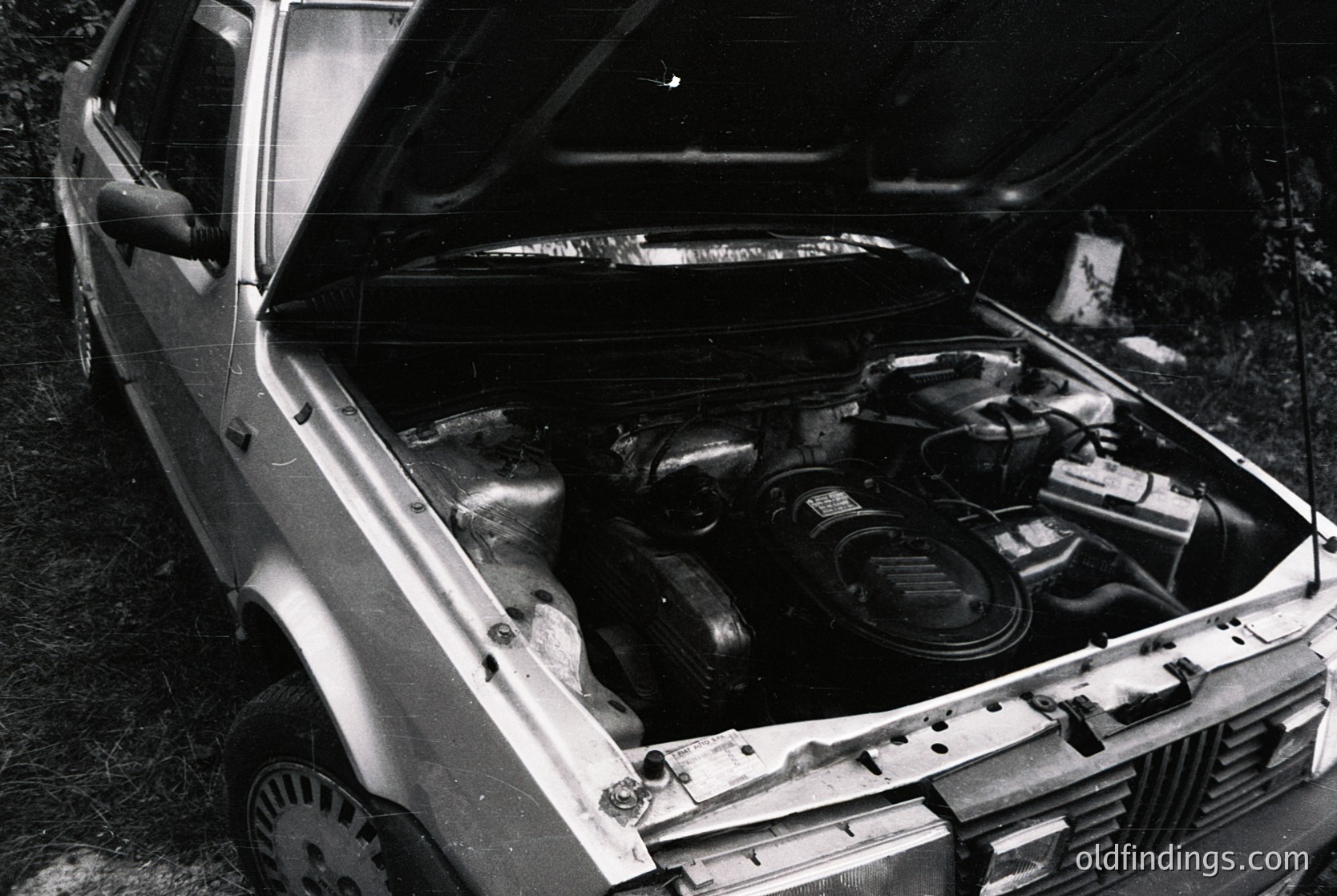 Classic inline-6 engine bay of a vintage European sedan, likely a **Volvo 700/760 series** (1980s). Distinctive Bosch fuel injection components and dual exhaust manifolds visible. Black-and-white photo highlights mechanical details over color. Ideal for automotive history, restoration guides, or stock imagery.