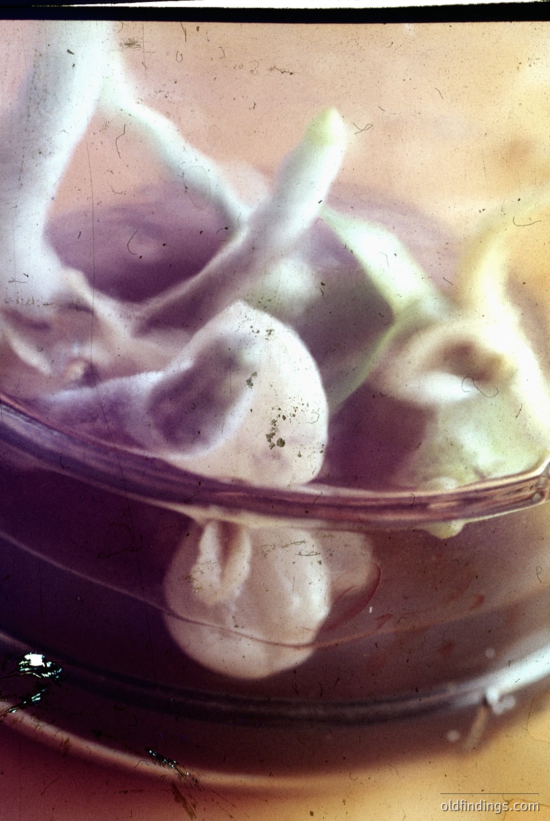 Vintage glass bowl filled with hand-cut, irregularly shaped soap pieces in a muted sepia tone. Likely mid-20th century household or barber shop soap.