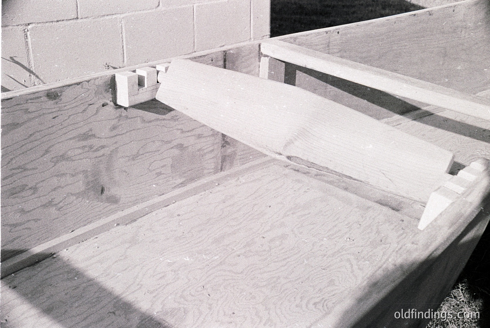 Industrial concrete slab with poured-in-place texture, framed by rough concrete edges and exposed rebar. Likely a mid-century construction detail, possibly for a foundation or floor slab.