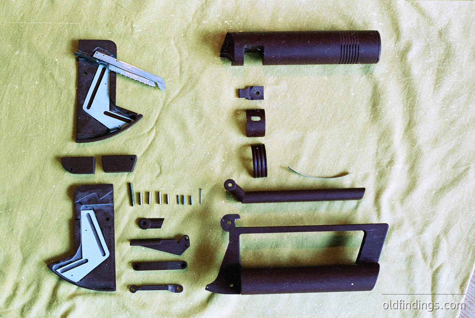 Disassembled metal components of a vintage firearm, likely a bolt-action rifle. Includes barrel, bolt carrier, firing pin, extractor, and magazine release. Stamped markings suggest mid-20th century European military design. Ideal for historical research or firearms enthusiasts.