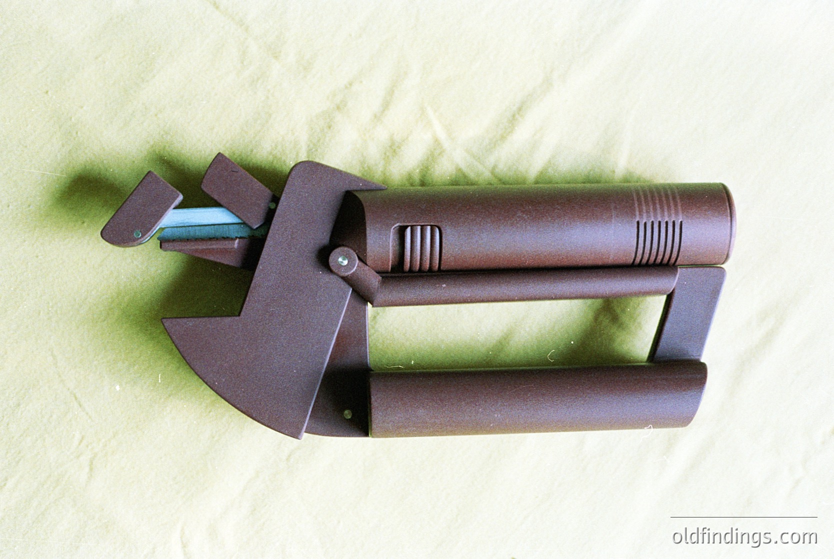 Vintage-style metal luggage handle with built-in hammer and screwdriver. Dark bronze finish with ribbed grip section and integrated tool attachments. Ideal for traveler’s toolkit or industrial design references.