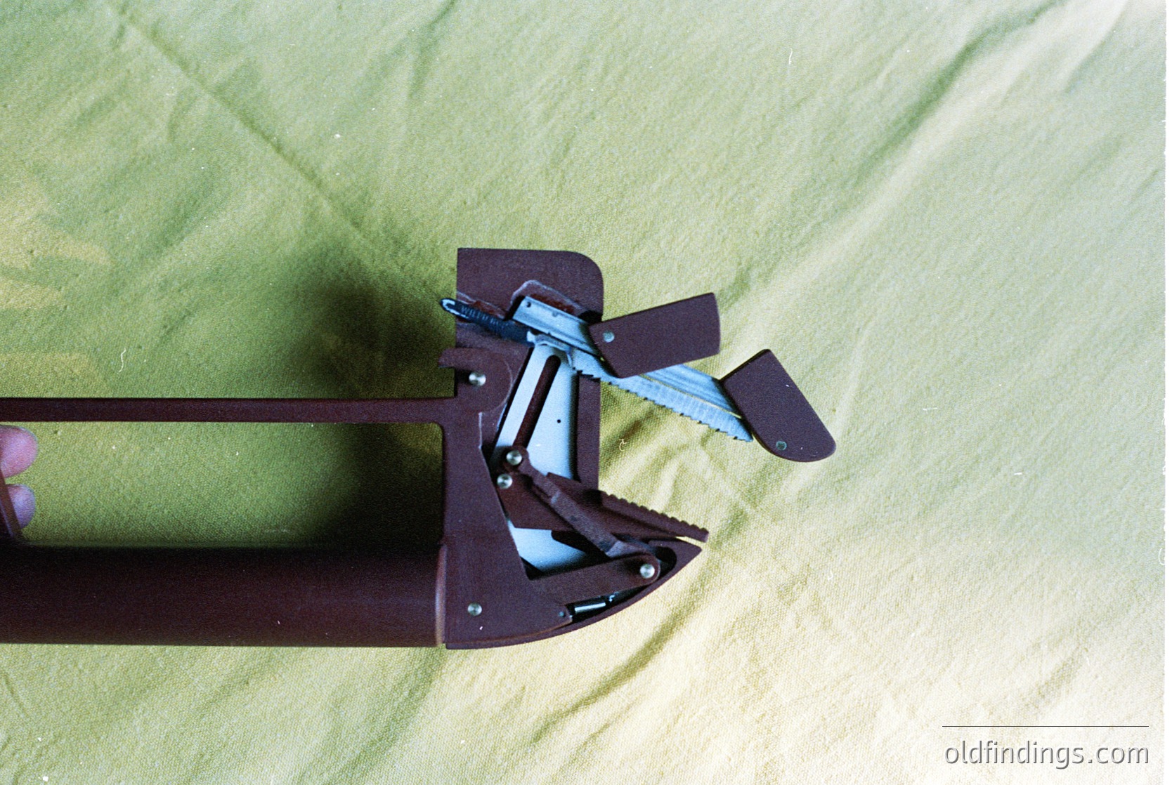 Close-up of a vintage **ski binding** with metal frame and adjustable toe piece, secured to a wooden ski. The binding’s riveted construction and exposed screws suggest mid-20th-century design. Ideal for historical ski equipment research or retro sports memorabilia.