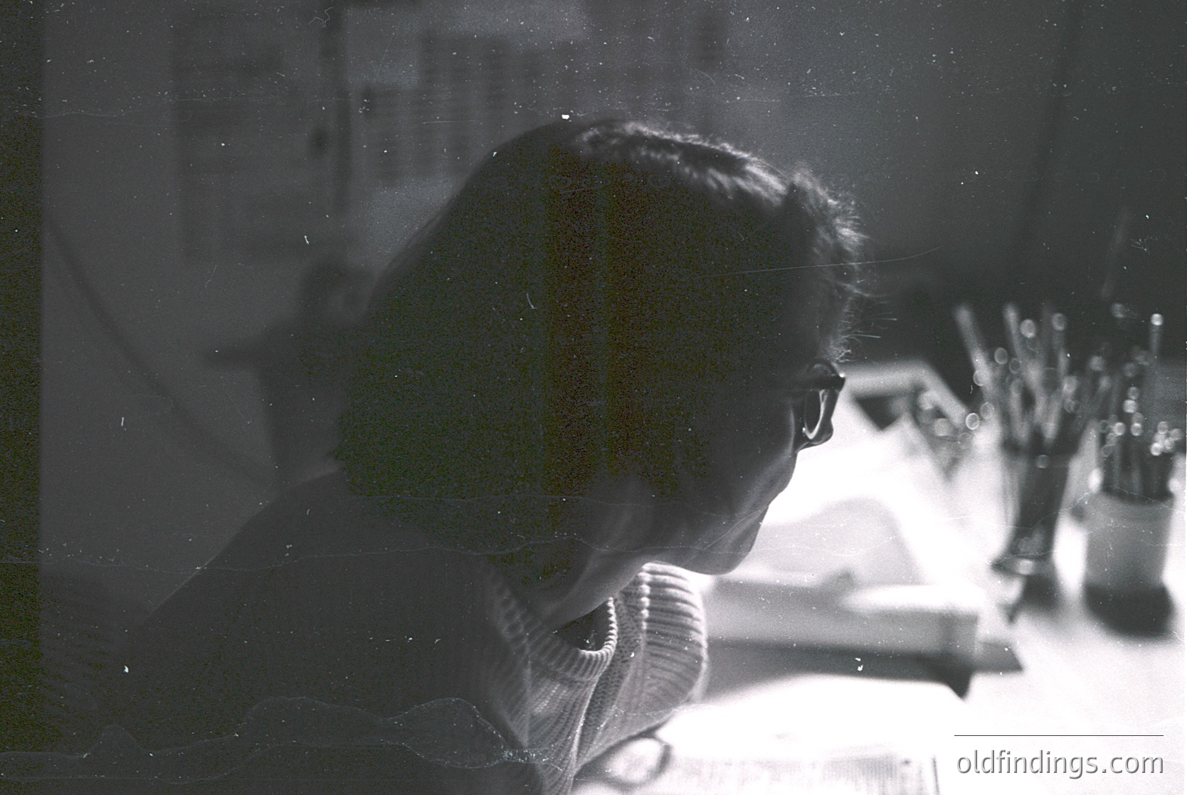 Silhouetted figure in mid-conversation on a vintage telephone, blurred vintage filter. Indoor setting with blurred floral arrangement and framed art in background. Likely mid-20th century domestic scene.