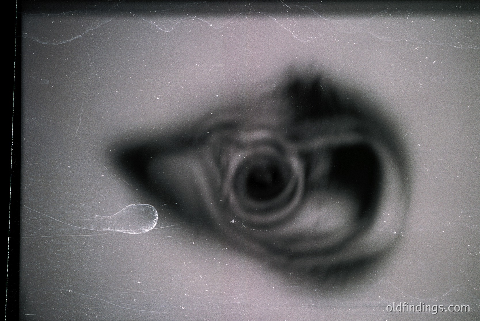 Vintage abstract photograph featuring blurred, swirling ink or paint on textured paper. Likely a 20th-century abstract art study or experimental photography.