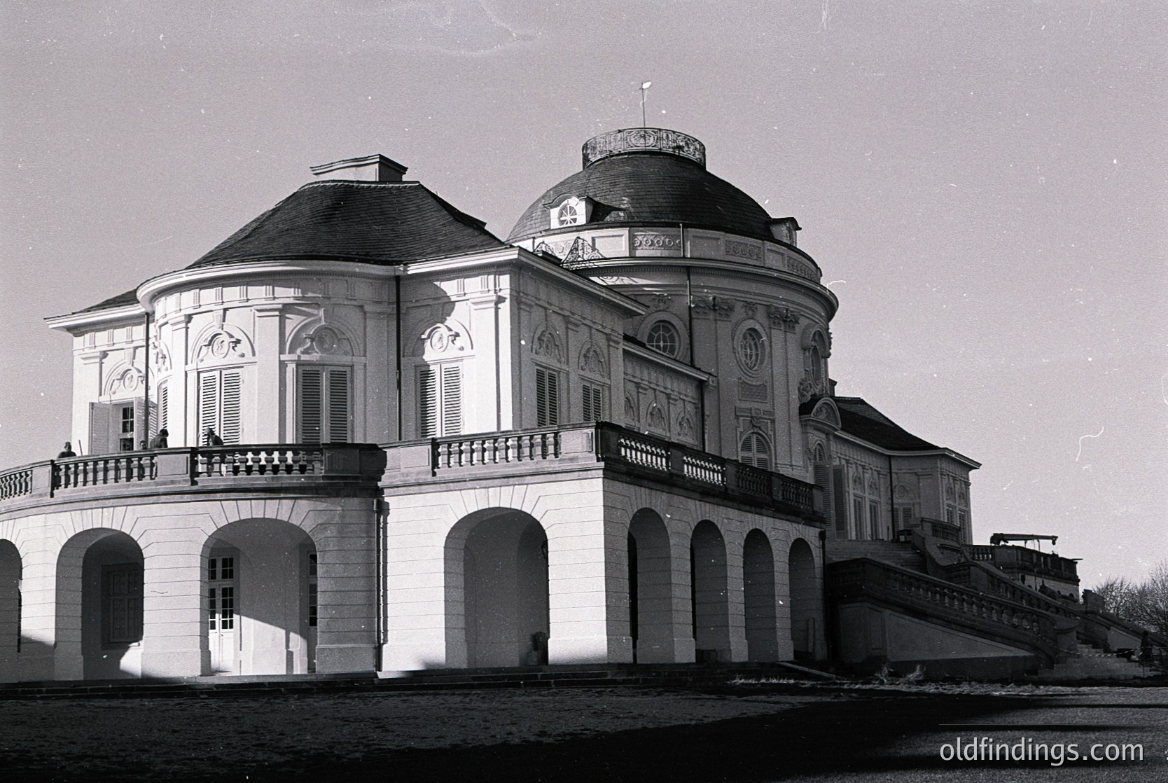 Neoclassical villa with domed roof and arched colonnades, likely 19th-century European architecture. Symmetrical design features decorative balustrades and pilasters. Waterfront setting suggests coastal or riverside location.