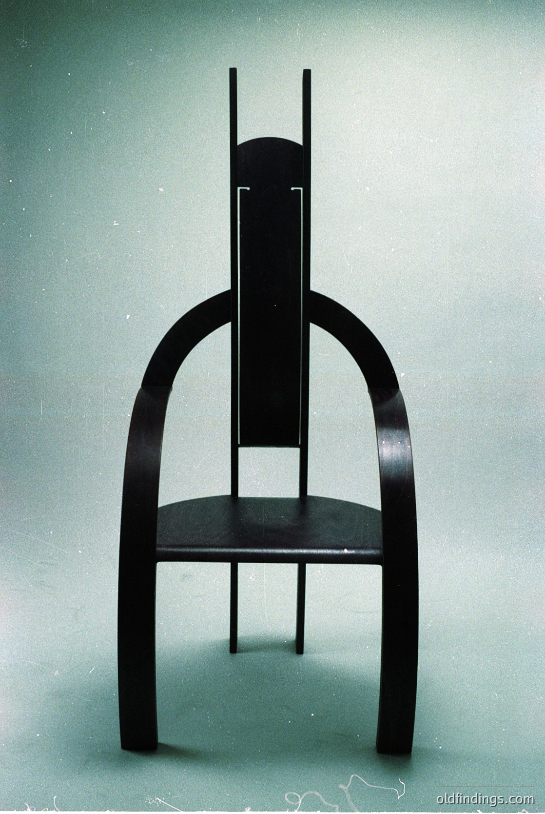 Mid-century modern chair with sleek, curved wooden legs and a minimalist seat. Dark-stained wood contrasts with clean, organic lines. Likely 1950s–1960s design, inspired by Scandinavian or Bauhaus aesthetics.