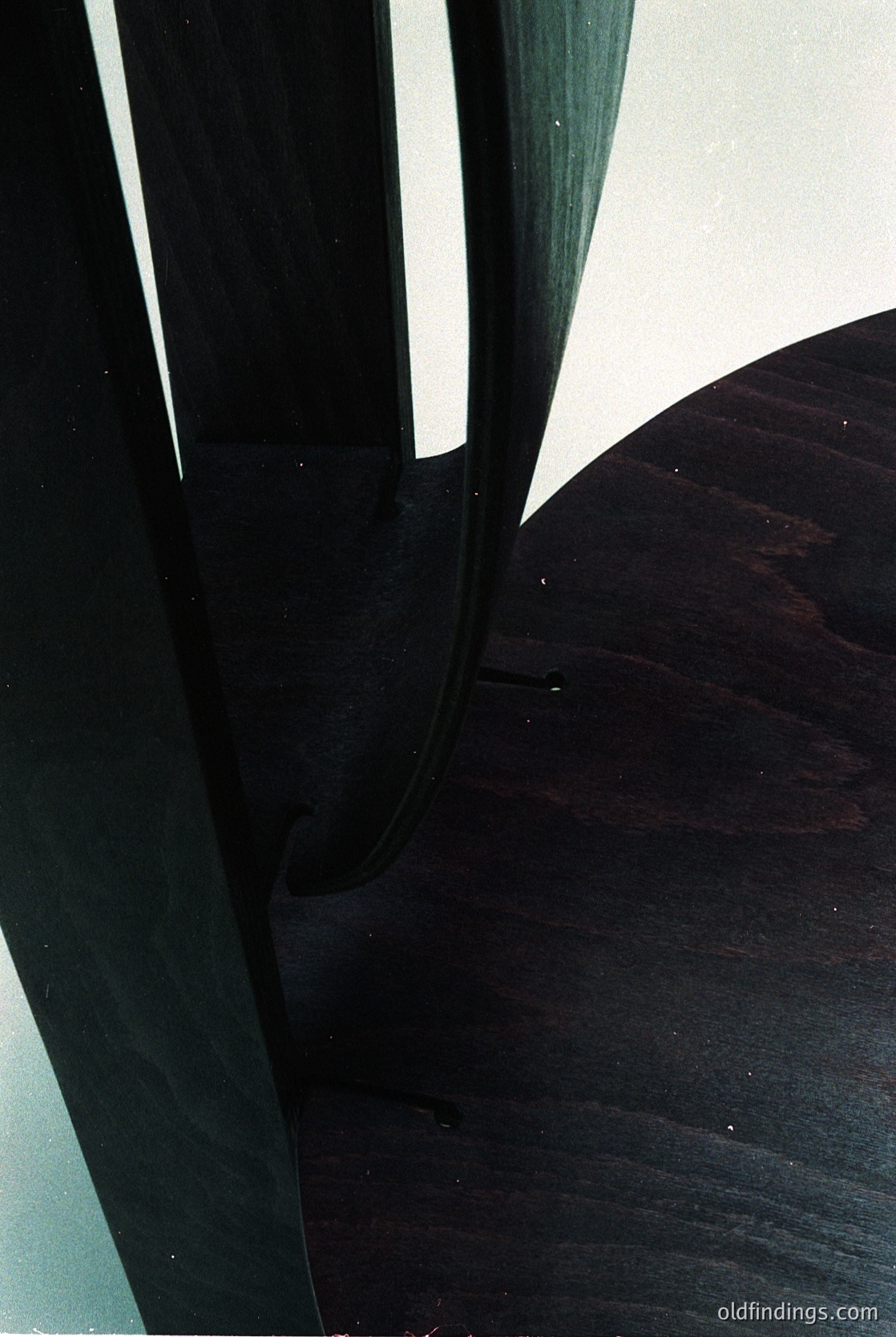 Mid-century modern chair legs in dark-stained wood, showcasing clean, tapered lines and organic curves. Likely from the 1950s–1960s, reflecting Scandinavian or American organic design principles.