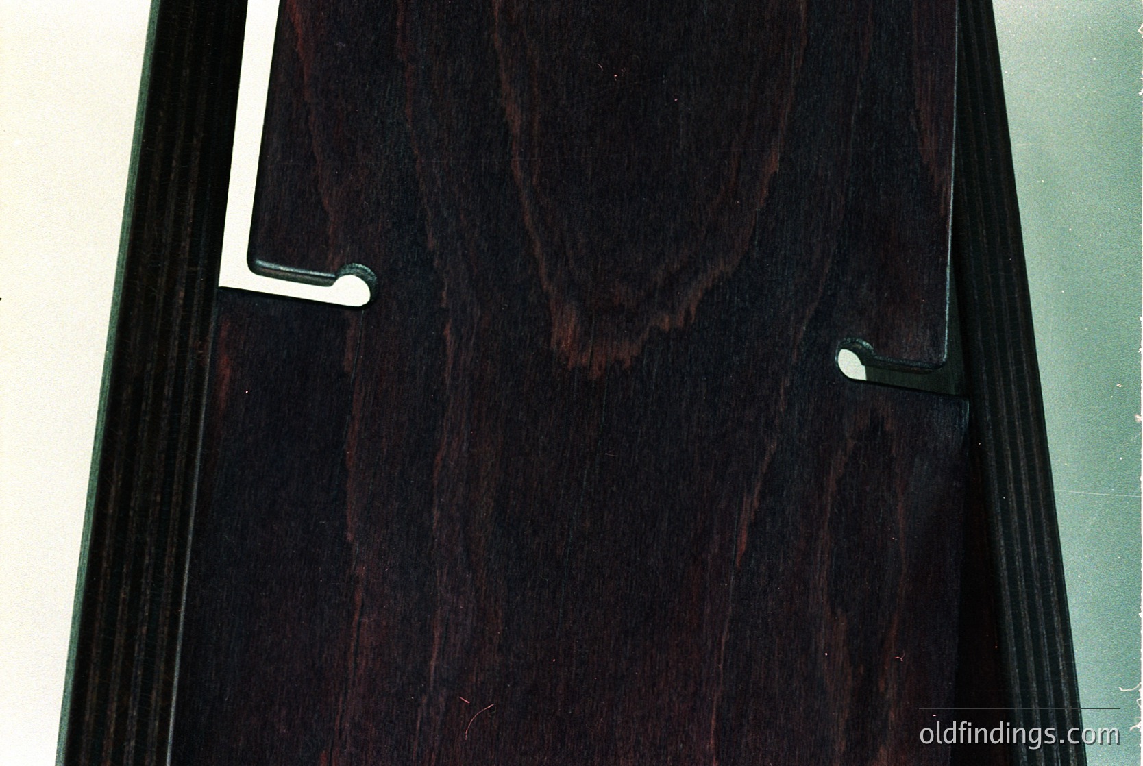 Dark-stained wooden interior door with vertical grain pattern and two metallic handles. Mid-century modern design with clean lines and minimalist hardware. Ideal for vintage interior design references or stock photography of classic door styles.