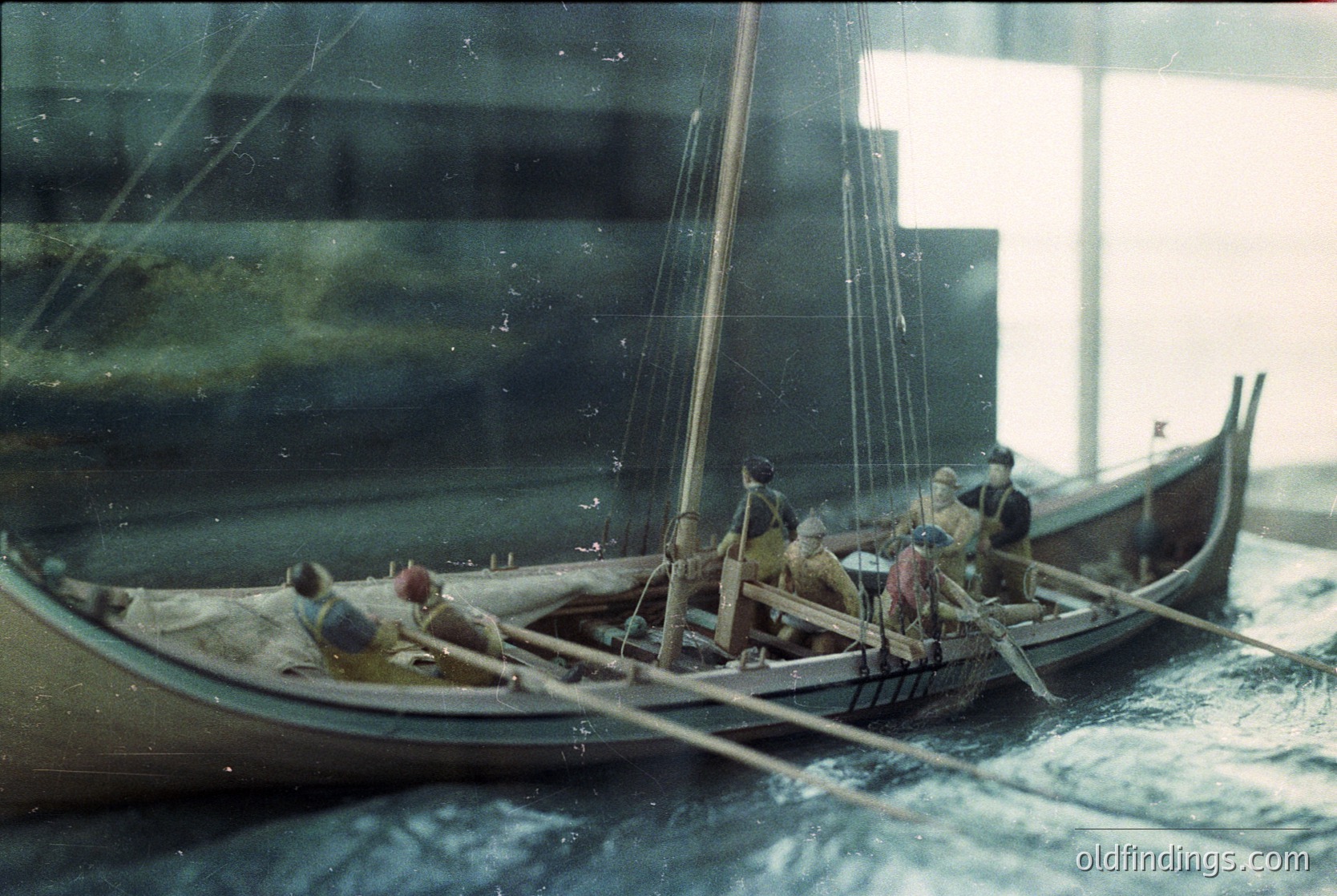 Viking-style longship model with crew in traditional attire, likely 9th–11th century Norse design. Wooden hull, oars, and mast suggest maritime trade or warfare. Indoor display setting ( )