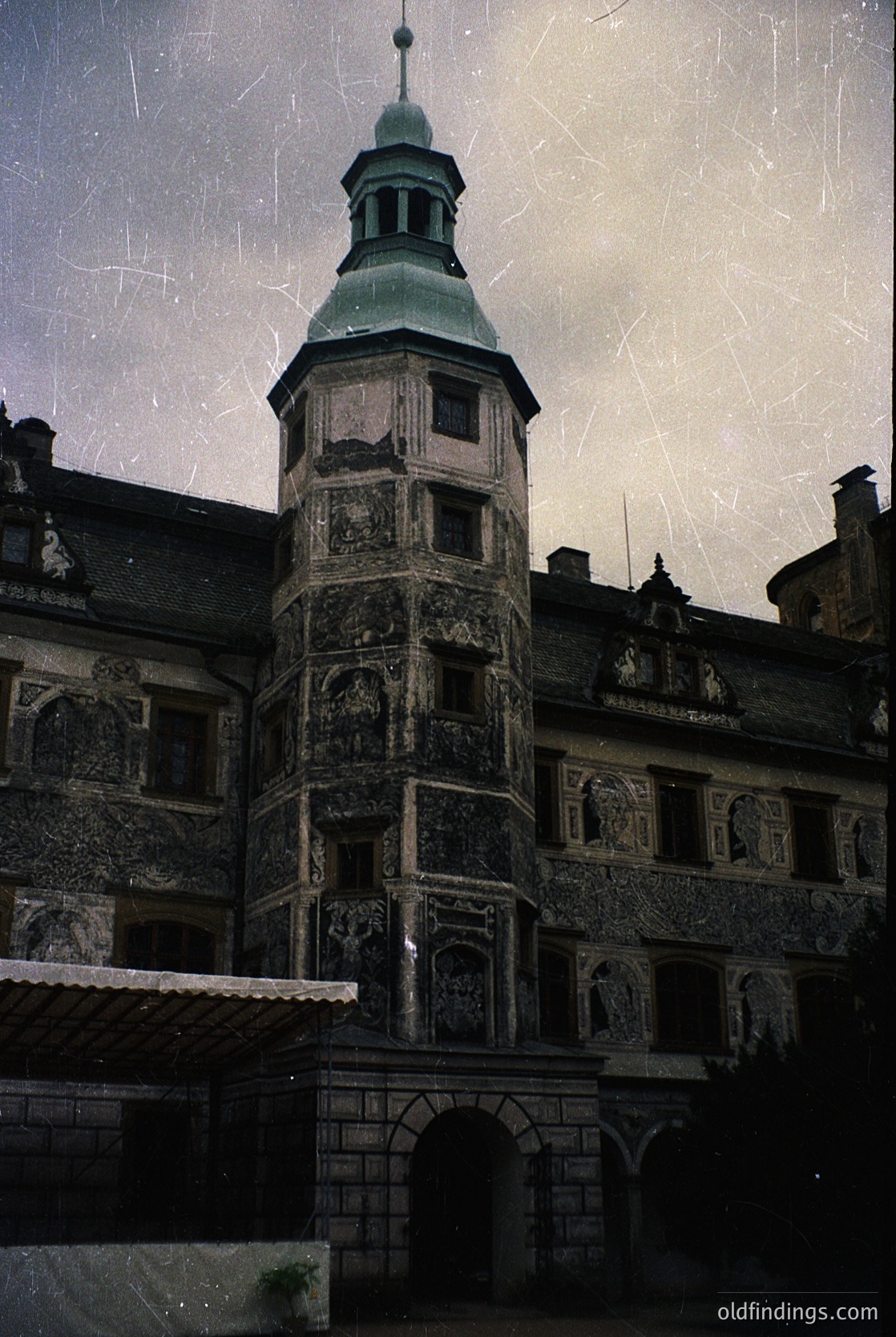 Historic stone tower with Renaissance Revival details—ornate carvings, arched windows, and a green-domed spire. Likely European, 19th-century architectural style. Aged paper texture suggests archival or vintage stock use.