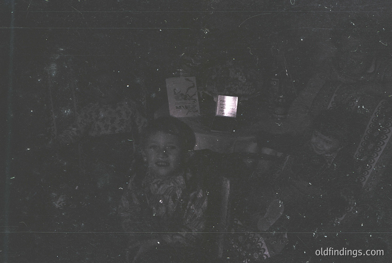 Vintage black-and-white photo of a child holding a lantern with Cyrillic script, likely Bulgarian. Indoor setting with rough stone walls and textured ceiling. Mid-20th century rural or industrial aesthetic.