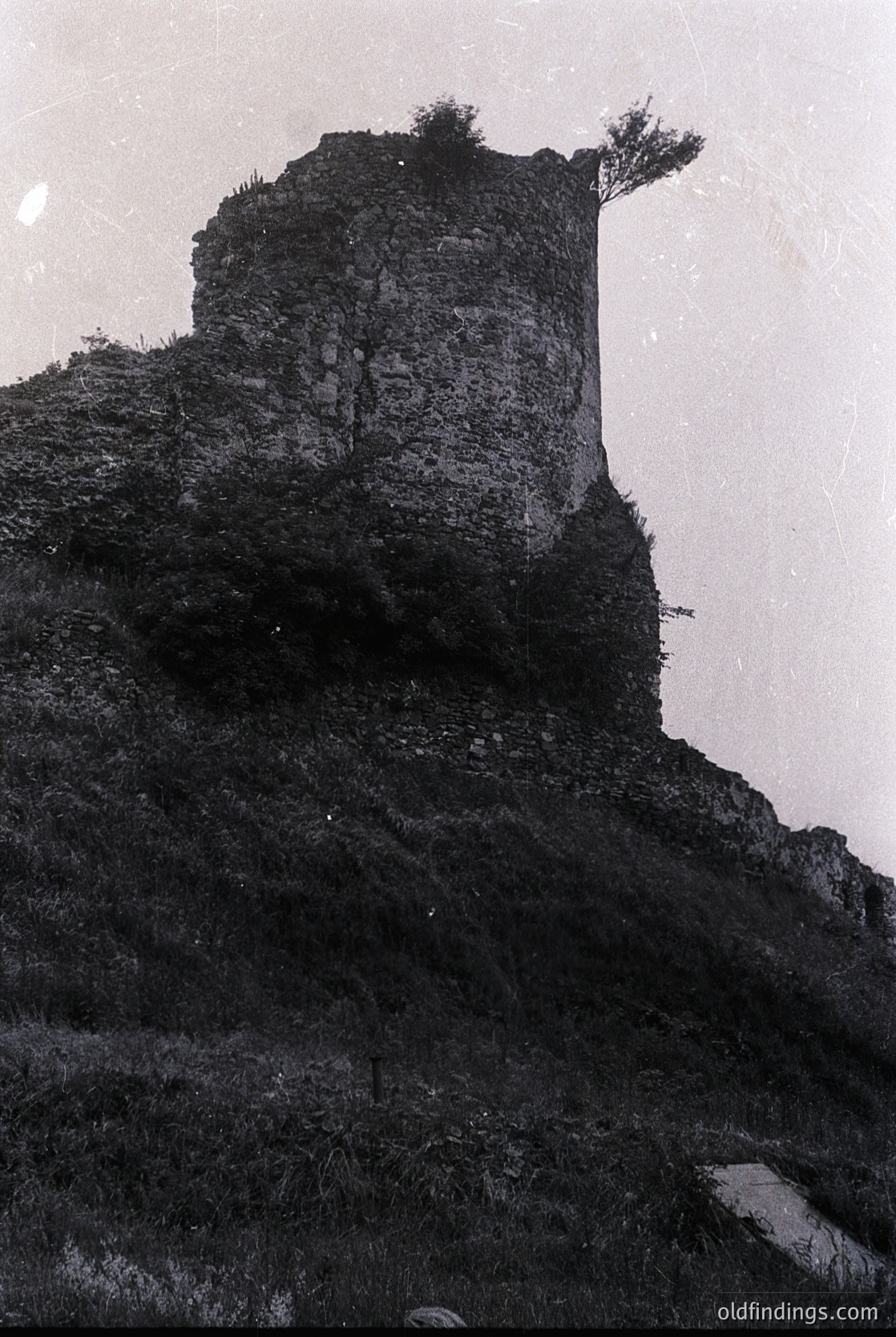 Medieval stone watchtower perched atop rugged cliff face, showcasing weathered masonry and sparse vegetation. Likely Eastern European, resembling a lookout or defensive structure from the 12th–15th century.
