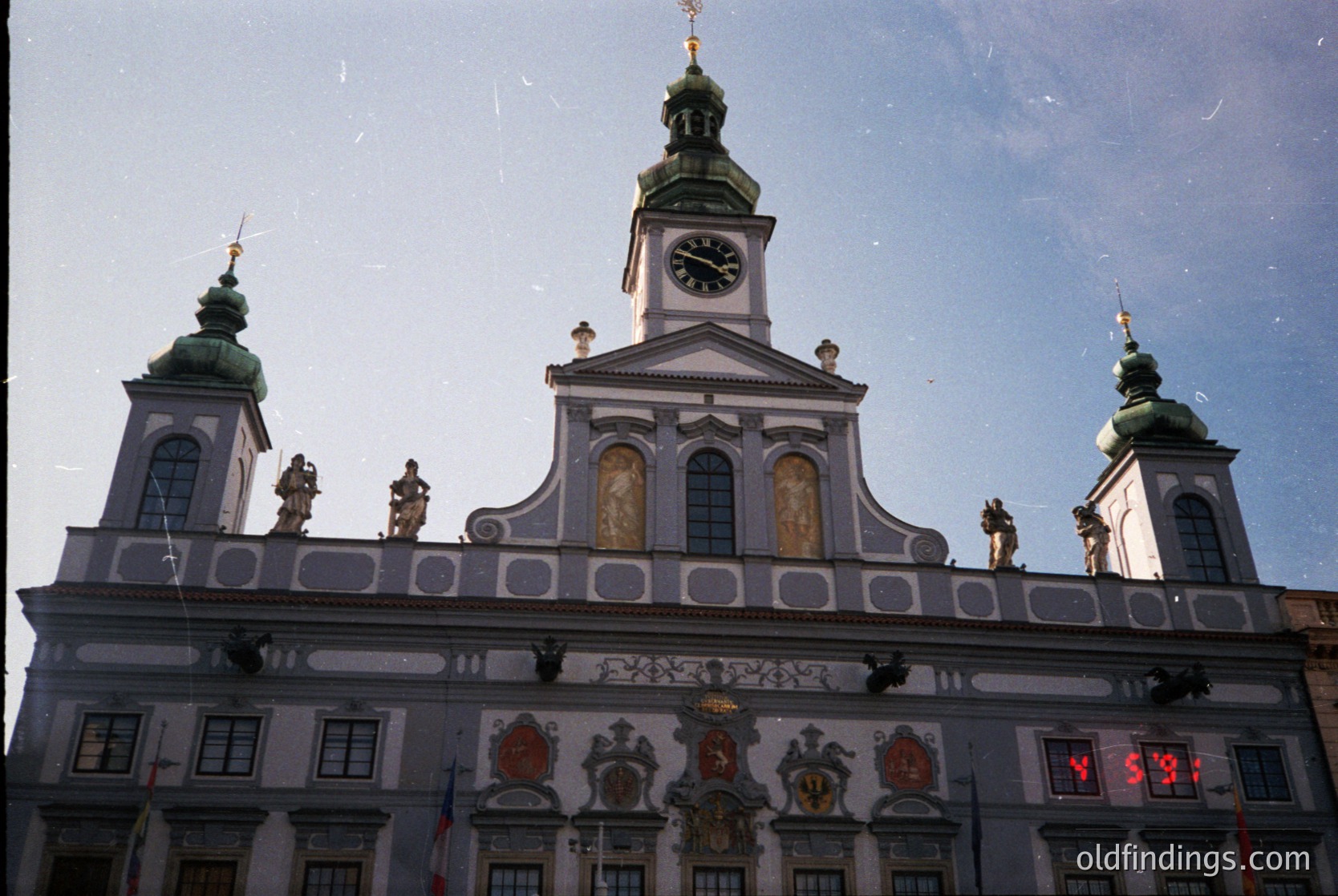 Baroque-style building façade with ornate clock tower, featuring sculpted figures, heraldic crests, and decorative moldings. Likely European, 17th–18th century. *(Note: Specific location cannot be confirmed without additional context, but architectural style suggests a European city center.)*