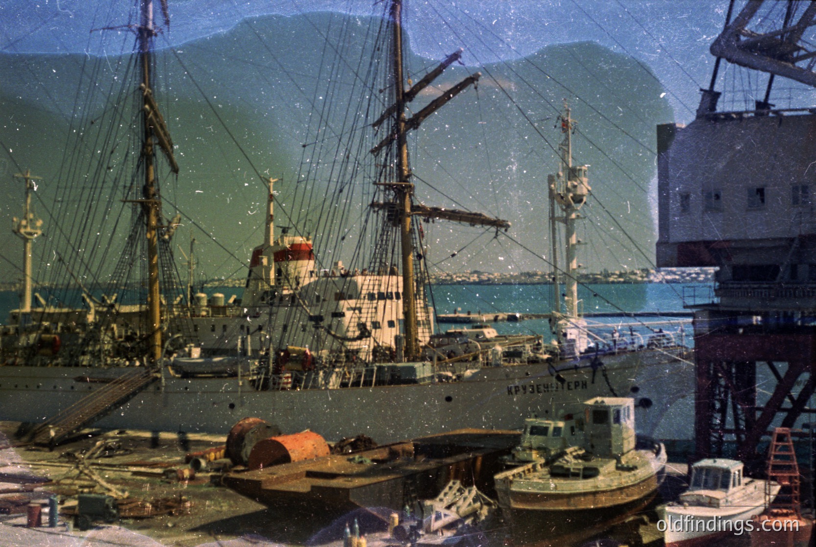 Vintage sepia-toned harbor scene featuring three-masted sailing ships and industrial tugboats. Prominent ship named *"АРХИПЕЛАГ"* (Archipelago) docked alongside cranes and warehouses. Coastal mountains in background suggest a sheltered port. Likely 1950s–1960s Soviet-era maritime activity.