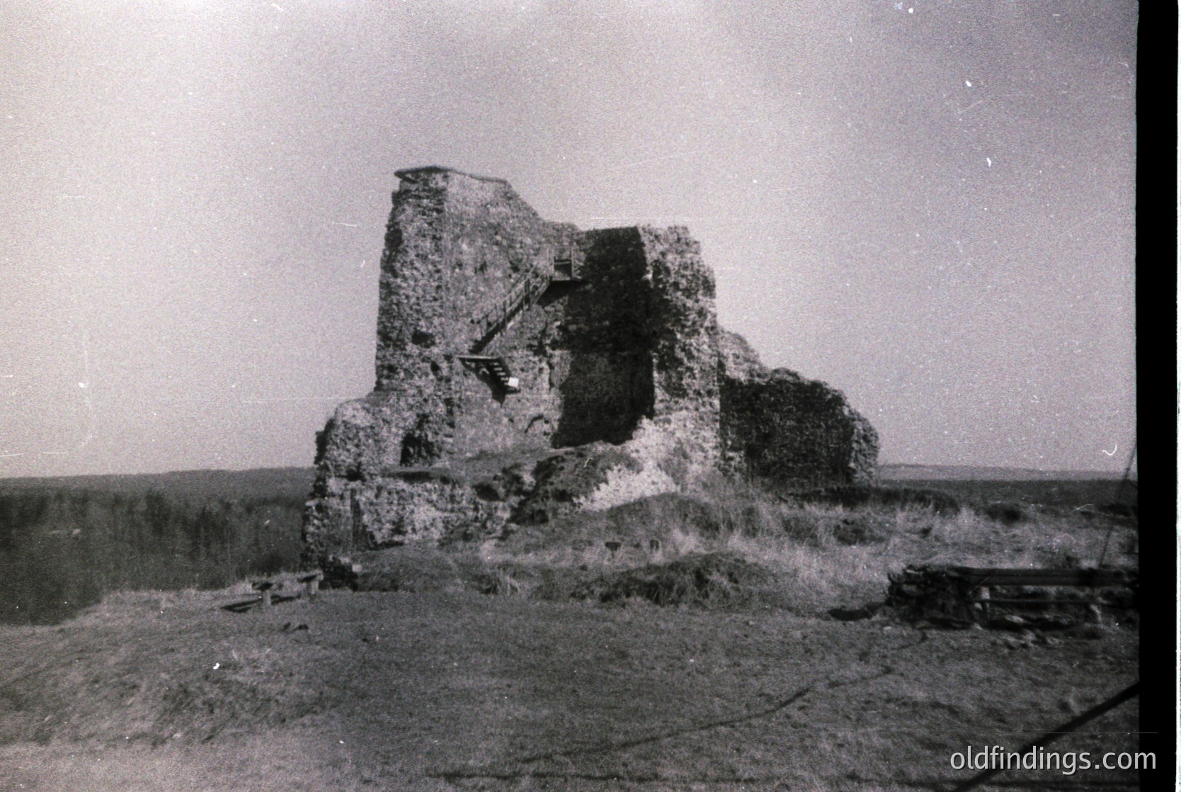 Ruined stone fortress with visible arched entrance and crumbling walls, set in an open landscape. Likely mid-20th century based on photographic style. Potential Eastern European location due to architectural style.