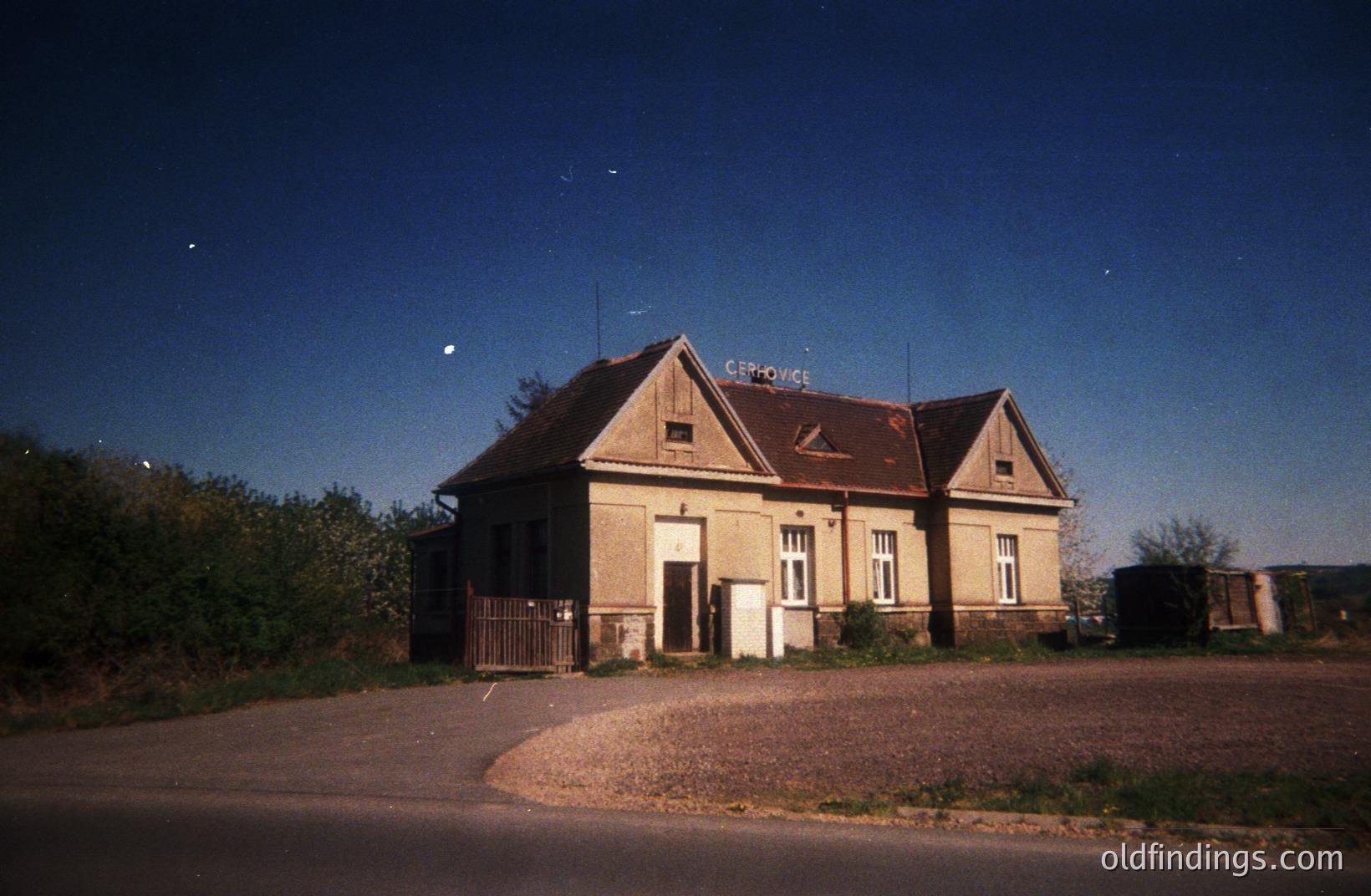 Abandoned train station building, likely in rural Central Europe. Features a gabled roof, brick facade with simple windows, and signage indicating "Čepovice". Possible 1970s timeframe. Atmospheric evening lighting. The neglected condition suggests disuse. #Čepovice