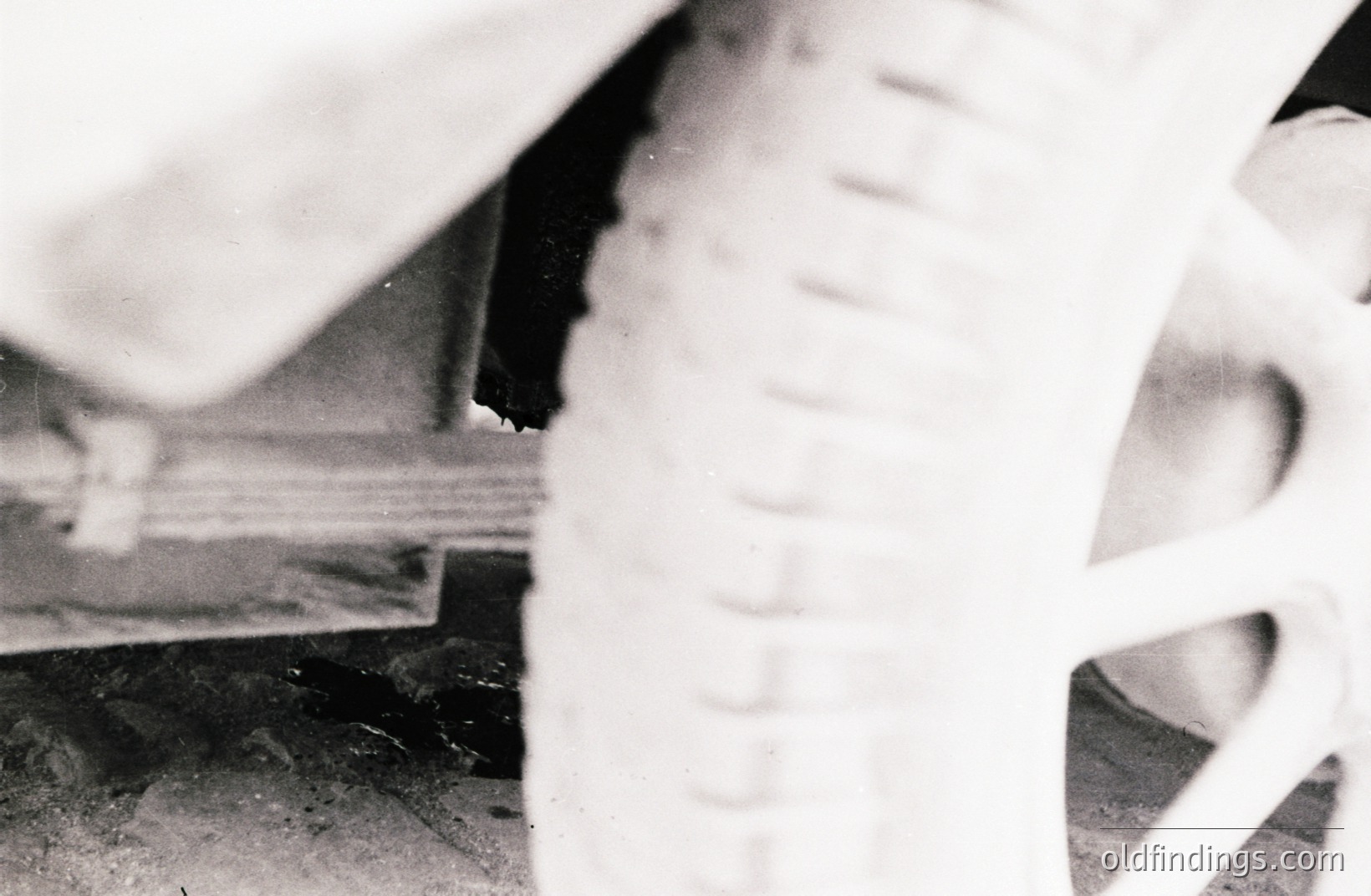 A close-up, black and white photo shows a tiled surface and a partial view of a modern, white ceramic sink. Distinctive vertical grooved texture on the sink’s exterior is prominent. Likely a domestic interior, possibly mid-century modern design aesthetic. Architectural detail and potential design reference.