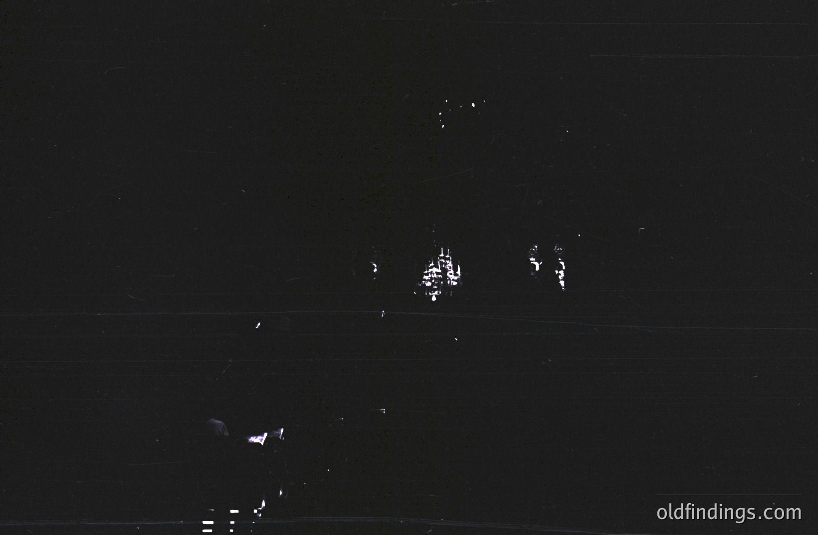 Nighttime photograph featuring illuminated structures against a dark sky, appearing blurred and indistinct. Possibly coastal architecture or city lights reflected on water. The image's limited detail suggests low light conditions and potential long exposure. Likely mid-20th century or later.