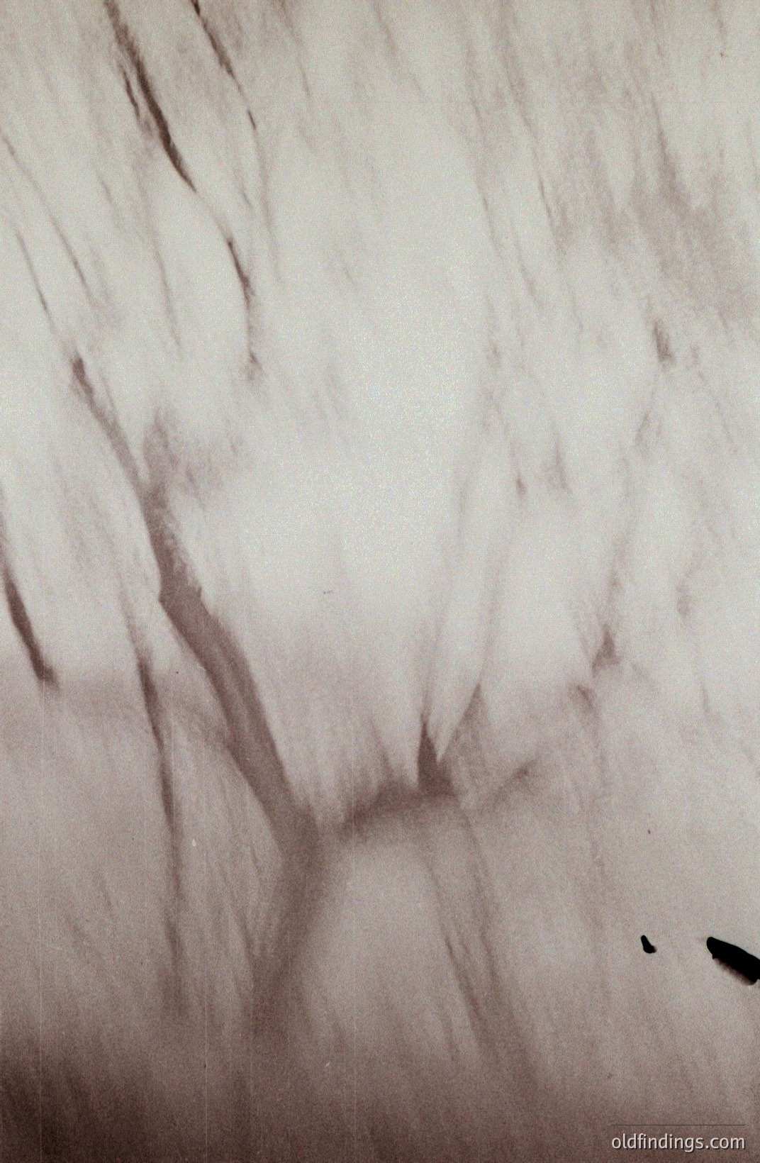 Striking, abstract monochrome image. Textured surface, possibly plaster or stucco, dominates the frame. A central, sculpted or carved depression creates a dramatic shadow play. Appears to be a detail shot, potentially architectural or artistic. Likely mid-20th century photographic style. Potential for design reference or textural background.