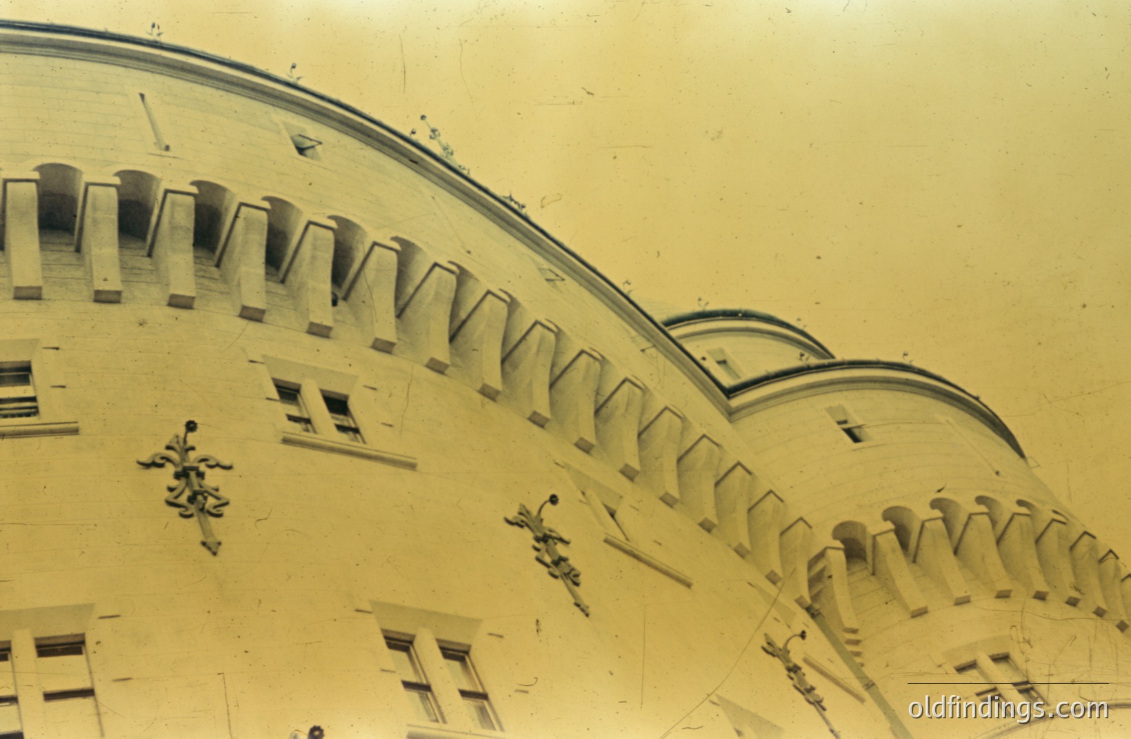 Detailed view of an ornate building façade with arched windows and decorative balustrades. Likely early 20th century architectural detail. The building’s style suggests European influence, possibly Mediterranean or Alpine. Shows elegant, repeating patterns.