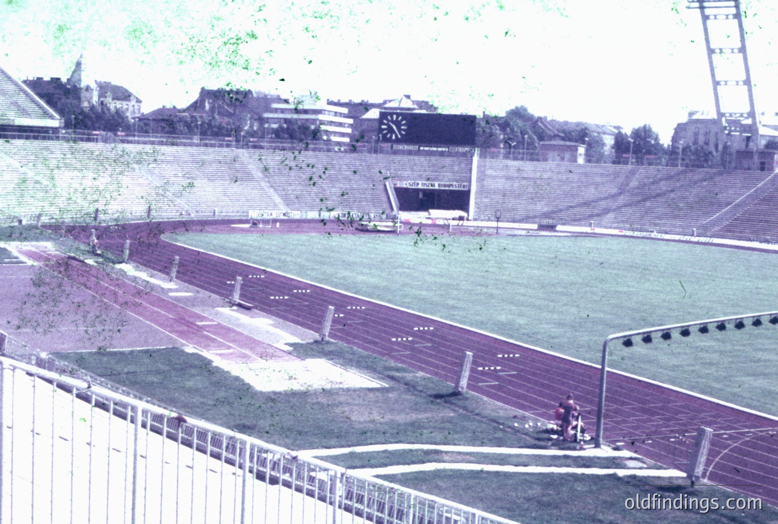 A wide view of a track and field stadium, likely intended for athletics or a similar sporting event. Visible are the running track lanes and a high jump apparatus. Tiered seating surrounds the field. Appears to be a vintage photograph, potentially from the 1960s-1970s.