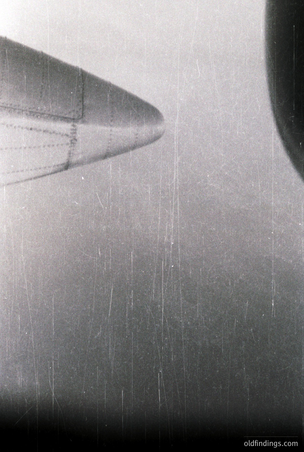 Close-up, black and white photograph of an aircraft nose section. Visible panel lines and rivets suggest a mid-century jet airliner. The image has significant grain and wear, indicative of film photography. Likely 1960s or 1970s era. Stock potential for aviation design and historical research.