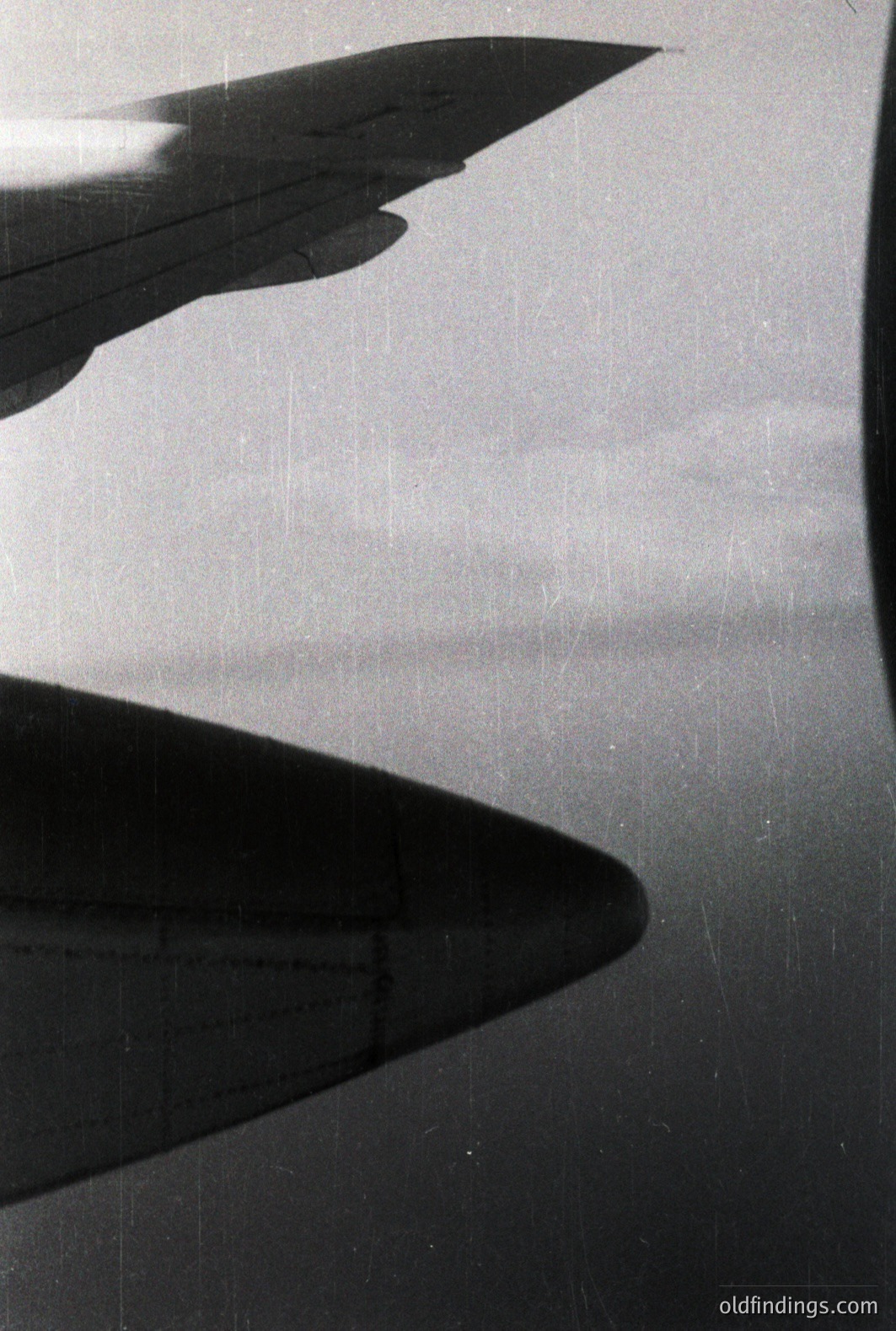 Striking black and white photo depicts a building's sharp, triangular form casting a dramatic shadow across a textured surface. Architectural detail suggests modernist design. Grainy quality and film scratches hint at a mid-century origin. A strong compositional element for design & architectural study.