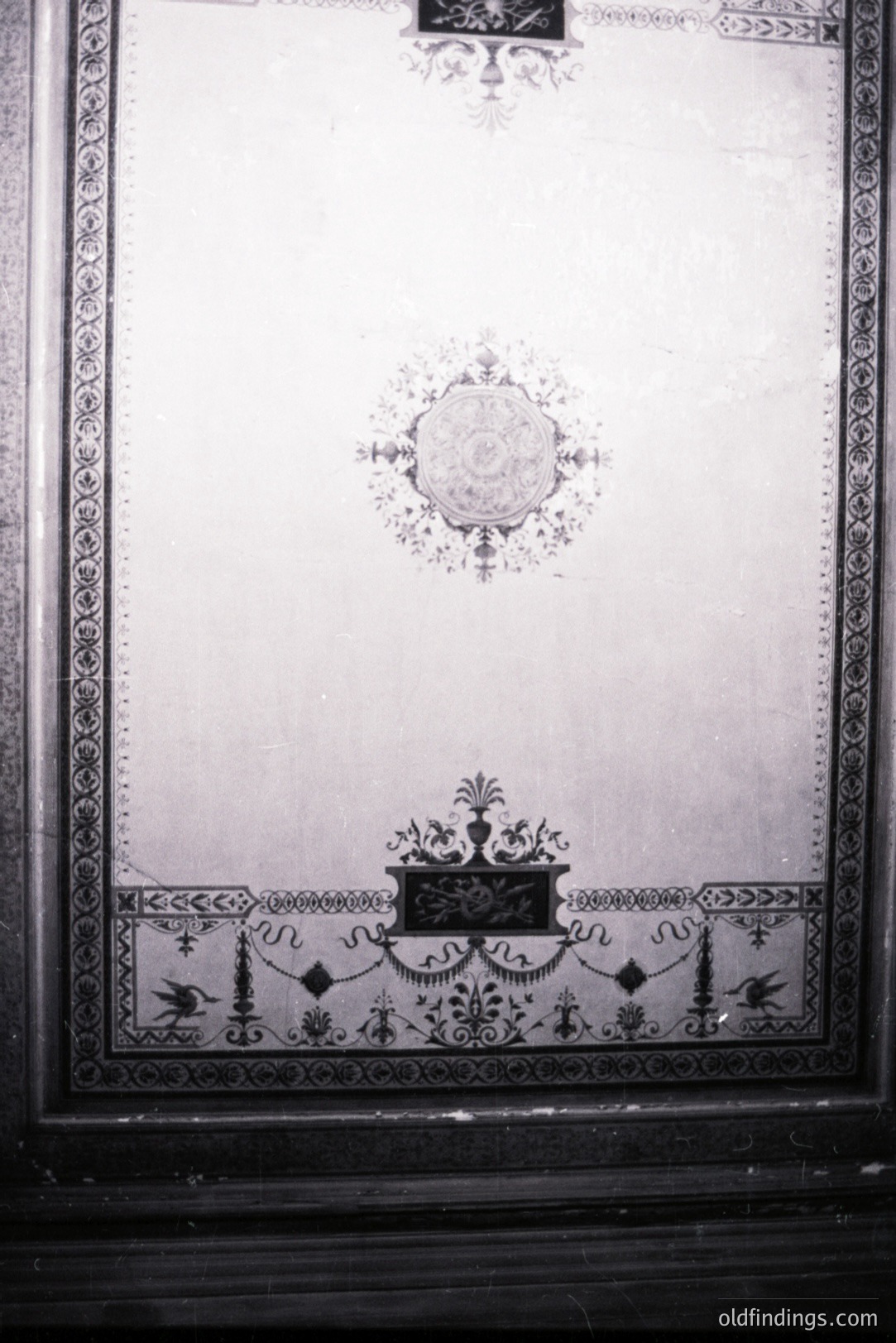 Decorative wall panel features ornate borders and symmetrical floral motifs, likely from an interior design element. The central oval design is framed by scrolling foliage, typical of late 19th/early 20th century interior detail. Possible French or Belgian origin.